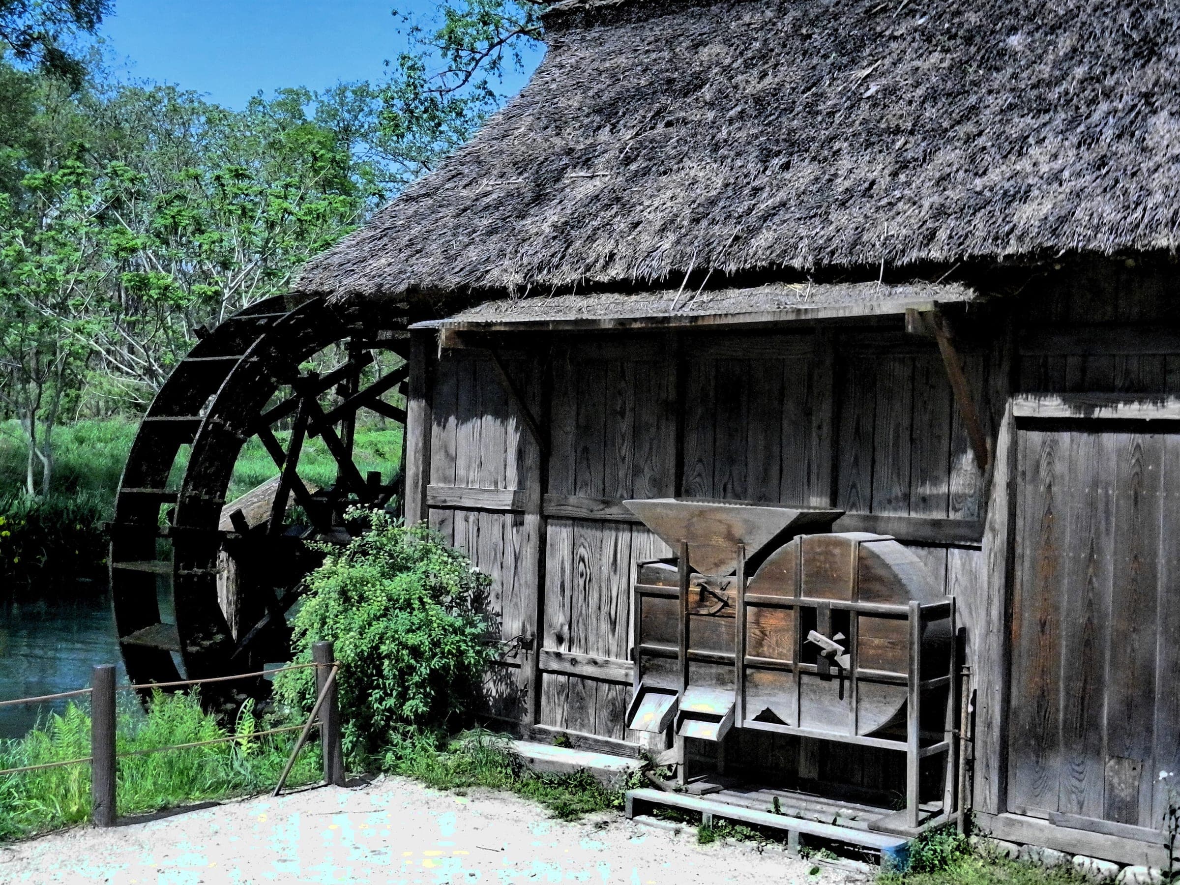 A thatched watermill hut stands beside the clear stream at Daio Wasabi Farm in Azumino.