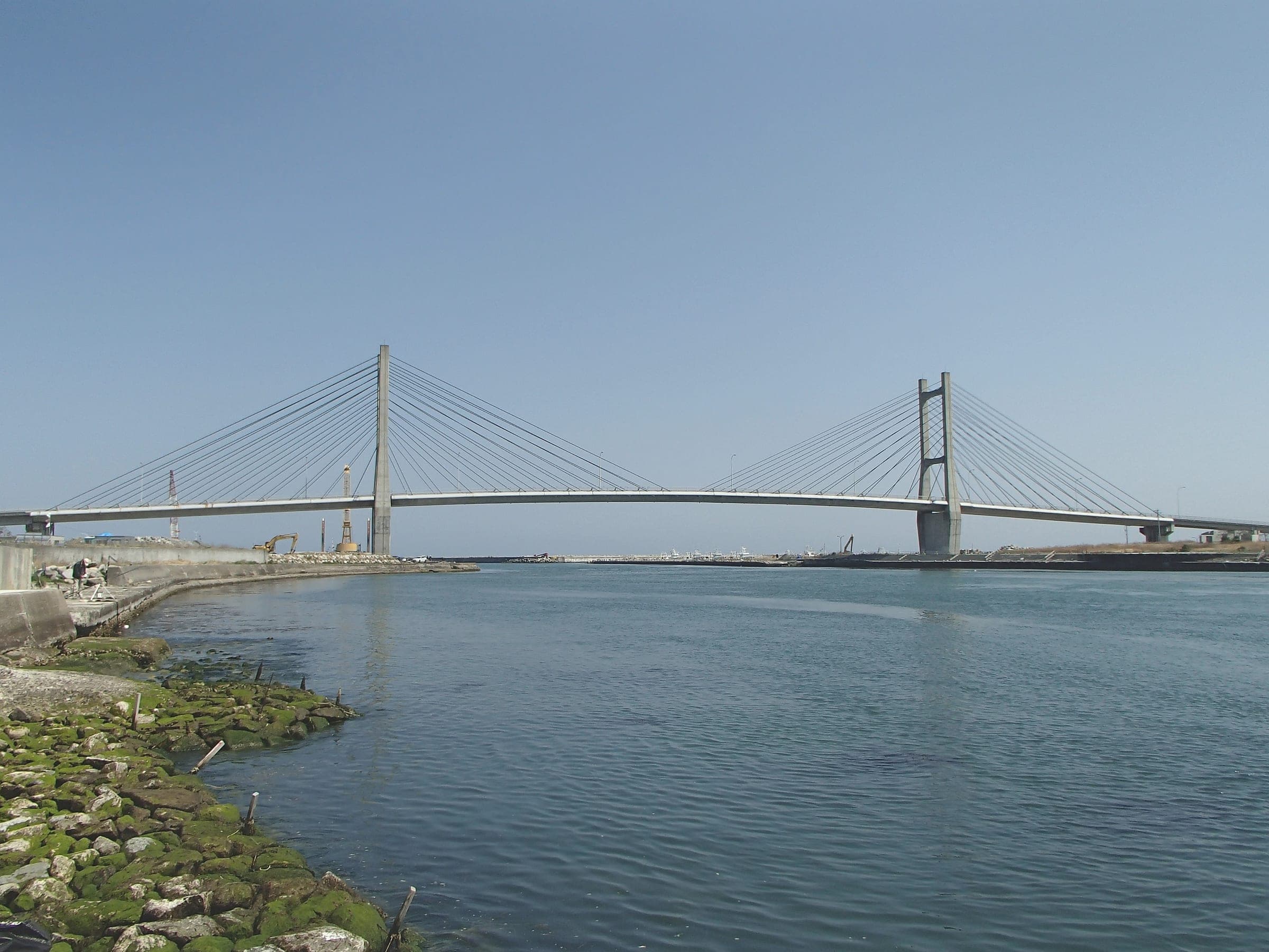 The cable-stayed Matsukawaura Bridge crosses the lagoon mouth at Soma under a clear spring sky.