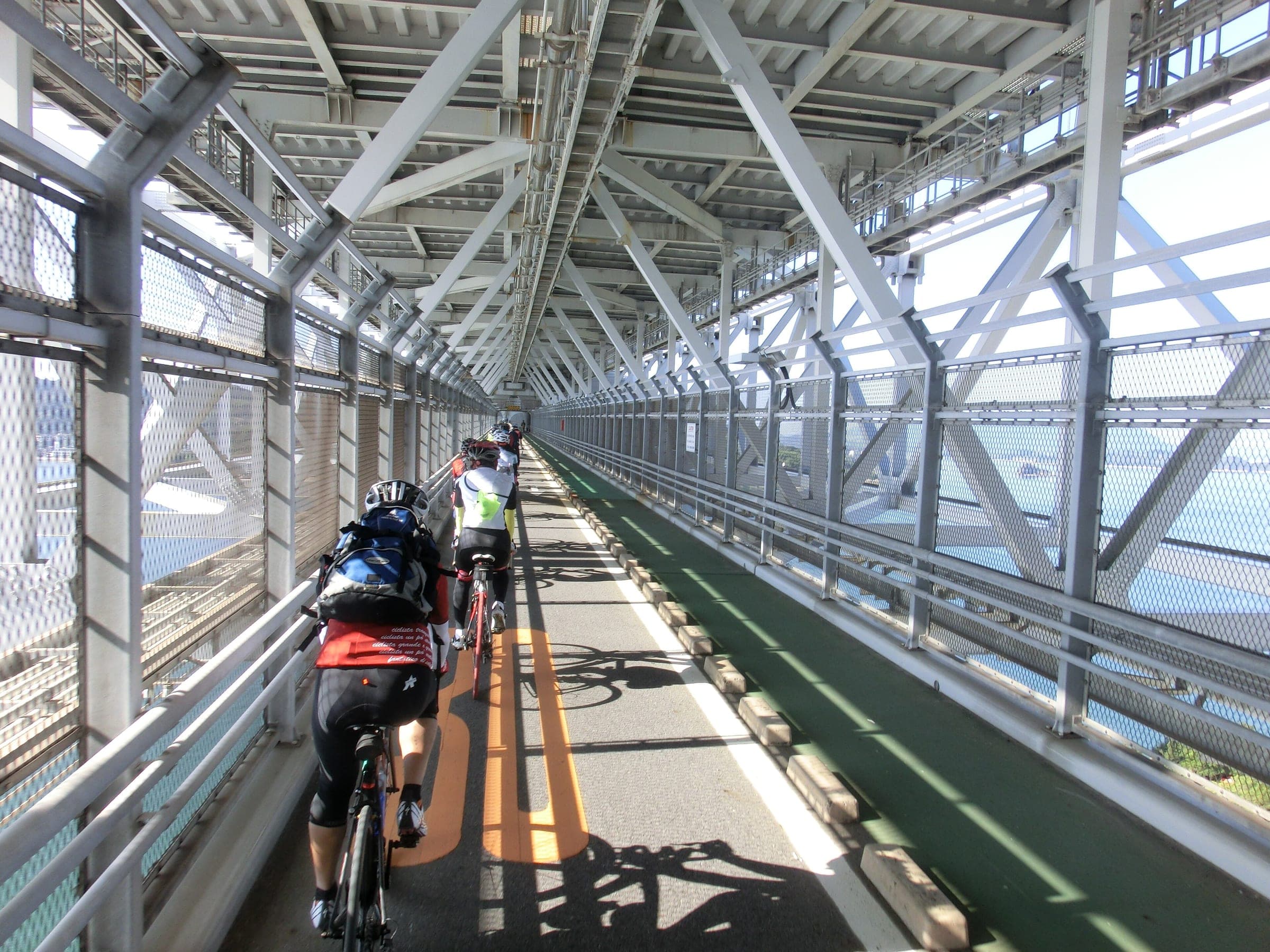 Cyclists ride the covered bike deck under the Innoshima Bridge on the Shimanami Kaido.