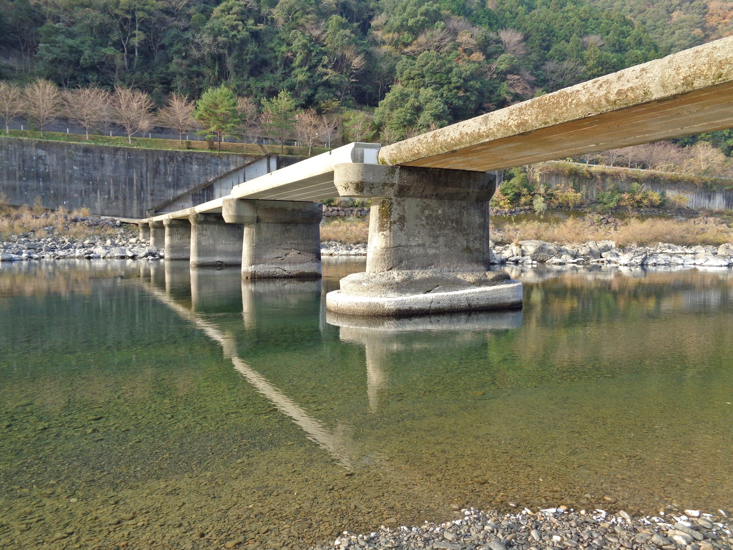 Clear water runs under the low concrete piers of the Nagaoi sinking bridge on the Shimanto River.
