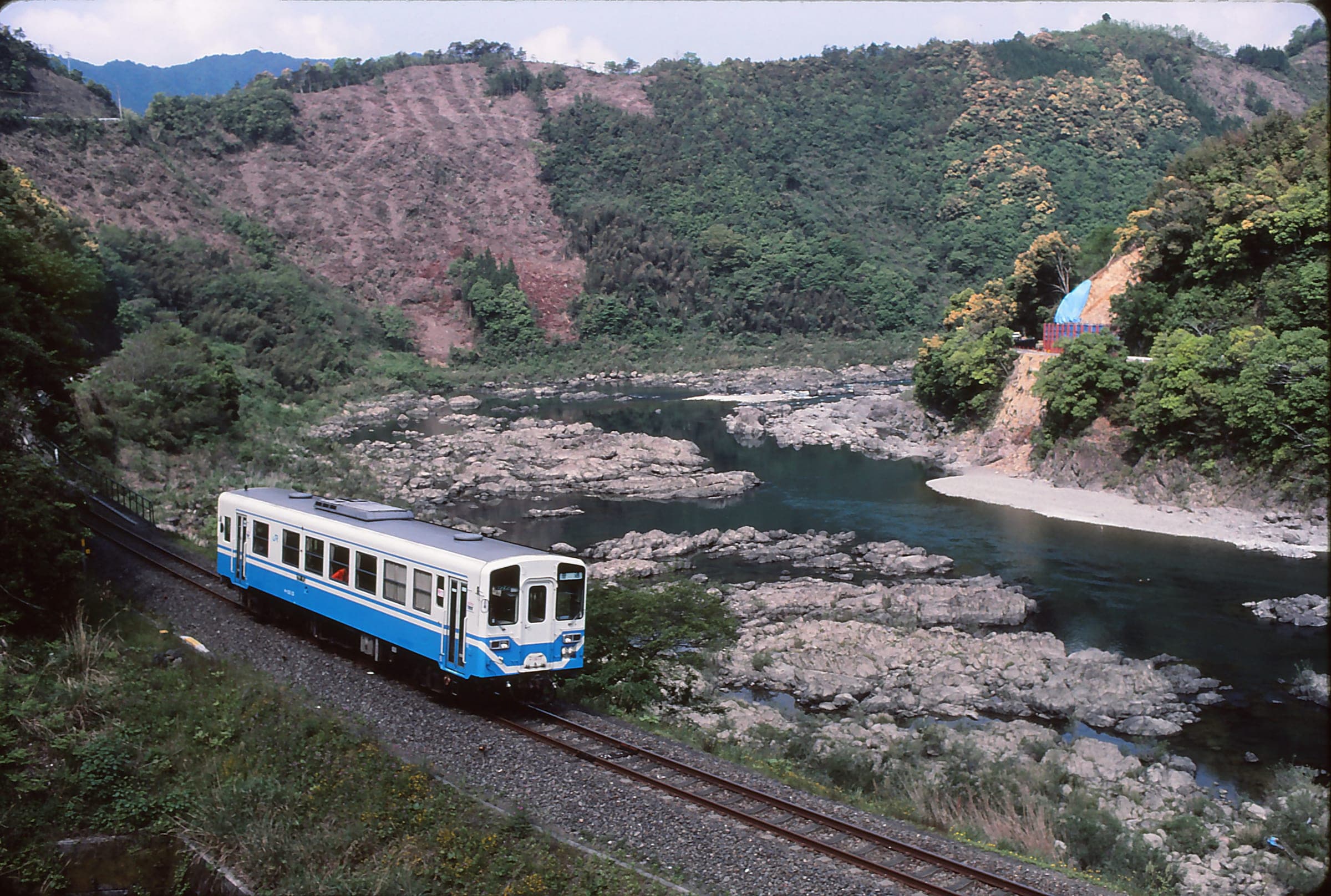 A Yodo Line railcar runs above the rocky Shimanto River between Tooka and Hage.