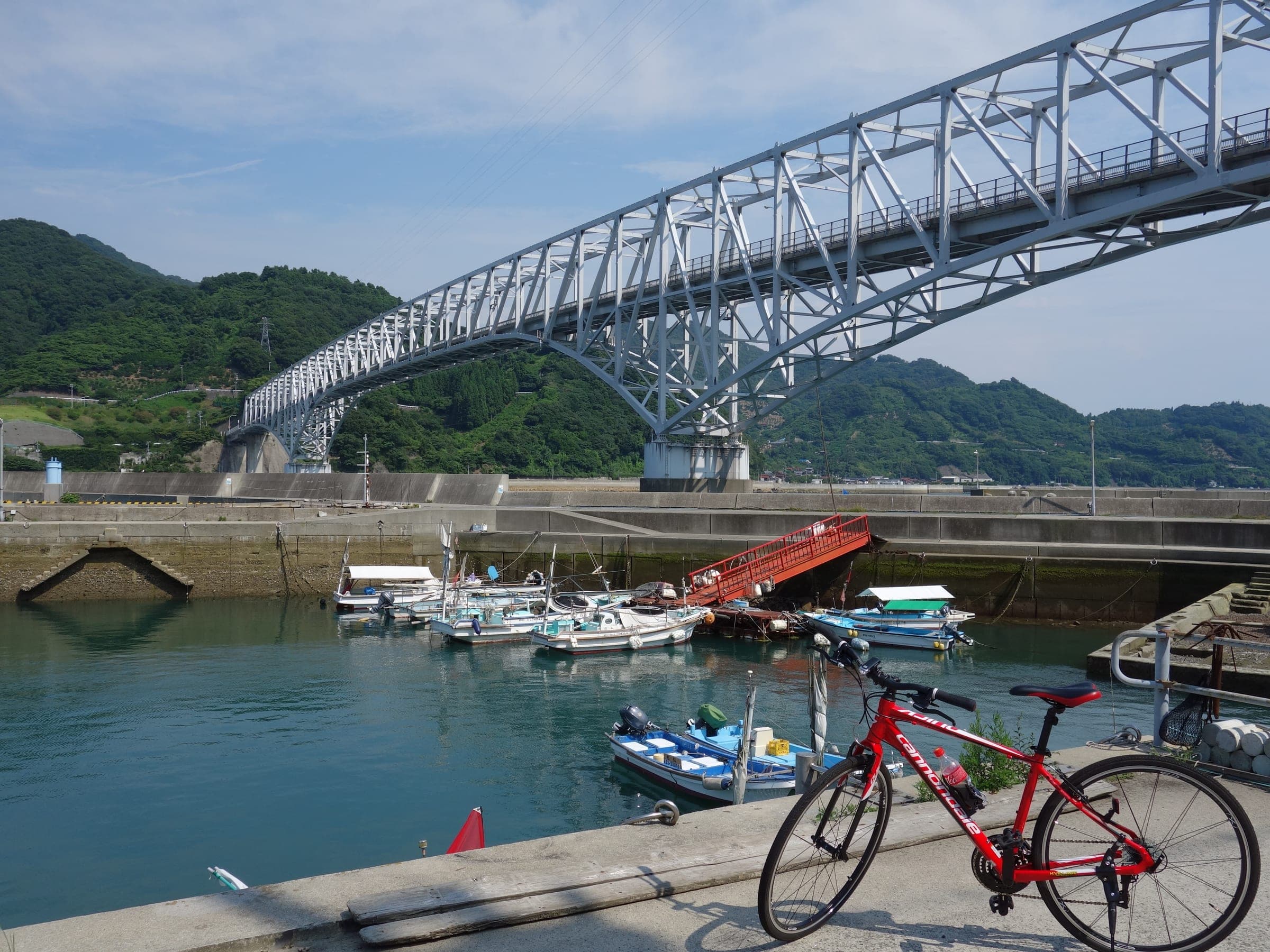 A road bike leans at a fishing harbour below the Toyohama Bridge on the Tobishima Kaido.