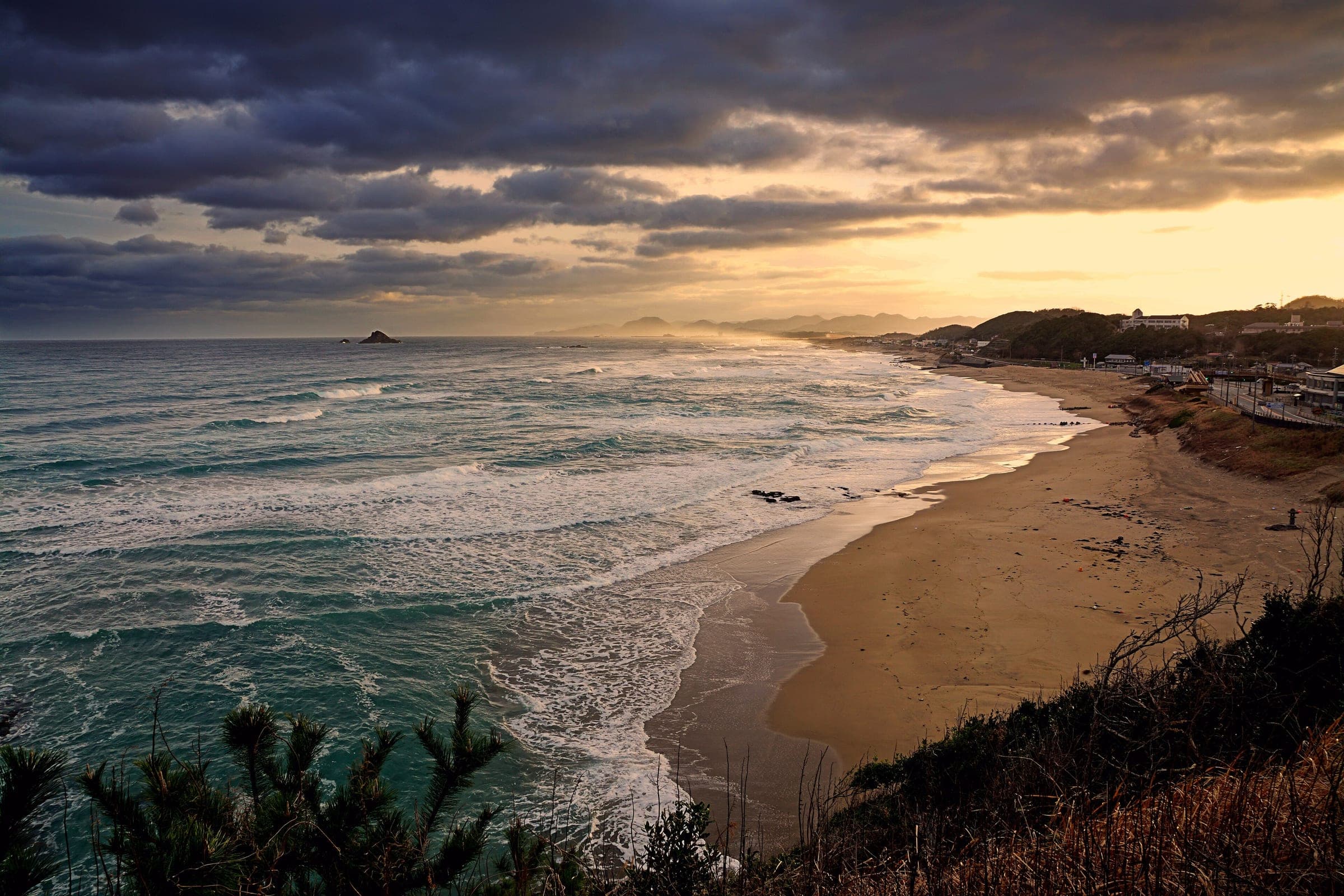 Morning light breaks over the surf and sand of the Hakuto Coast west of Tottori in January