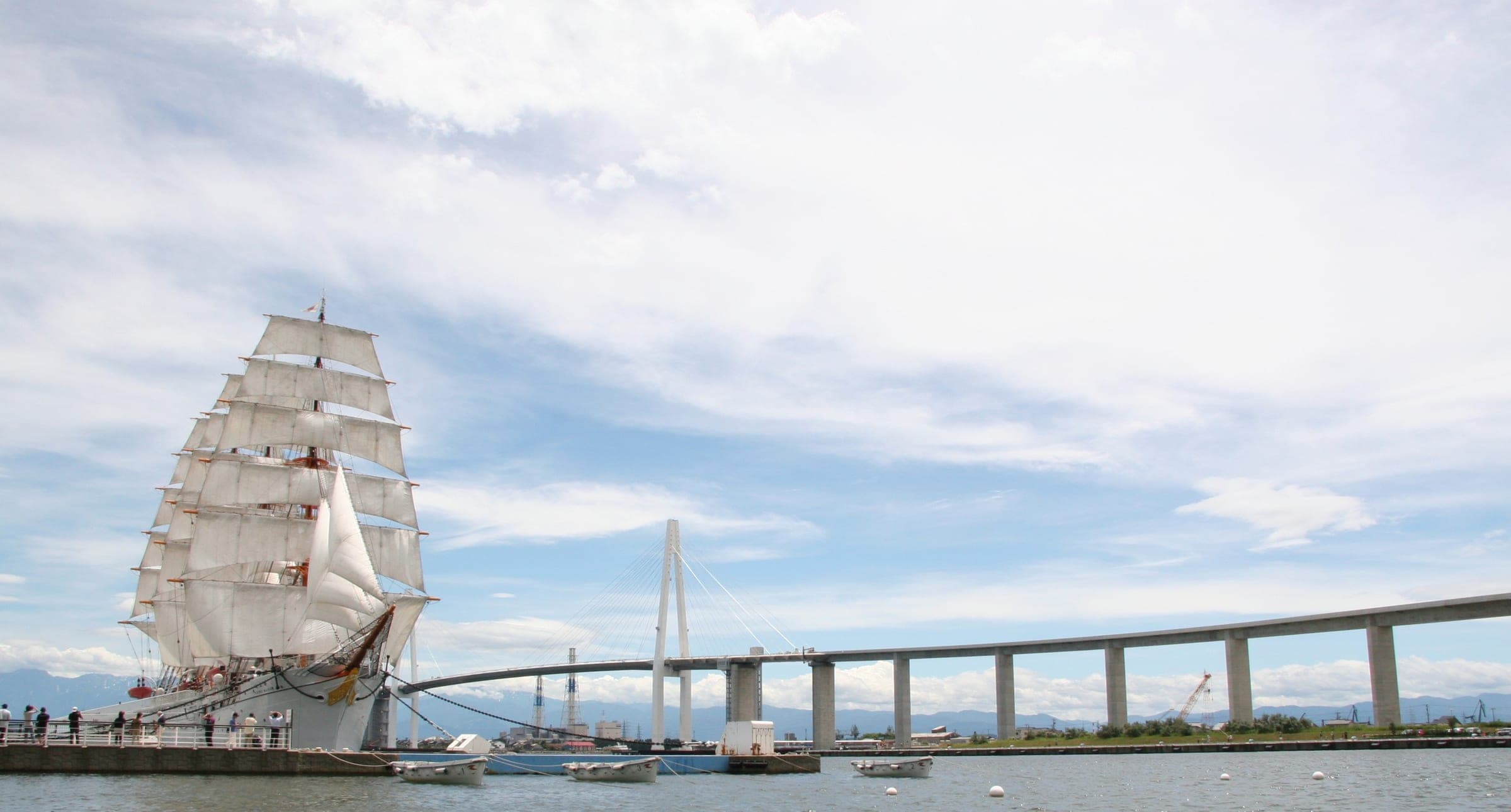 The tall ship Kaiwo Maru sets her sails beside the Shinminato Bridge at Kaiwo Maru Park on Toyama Bay
