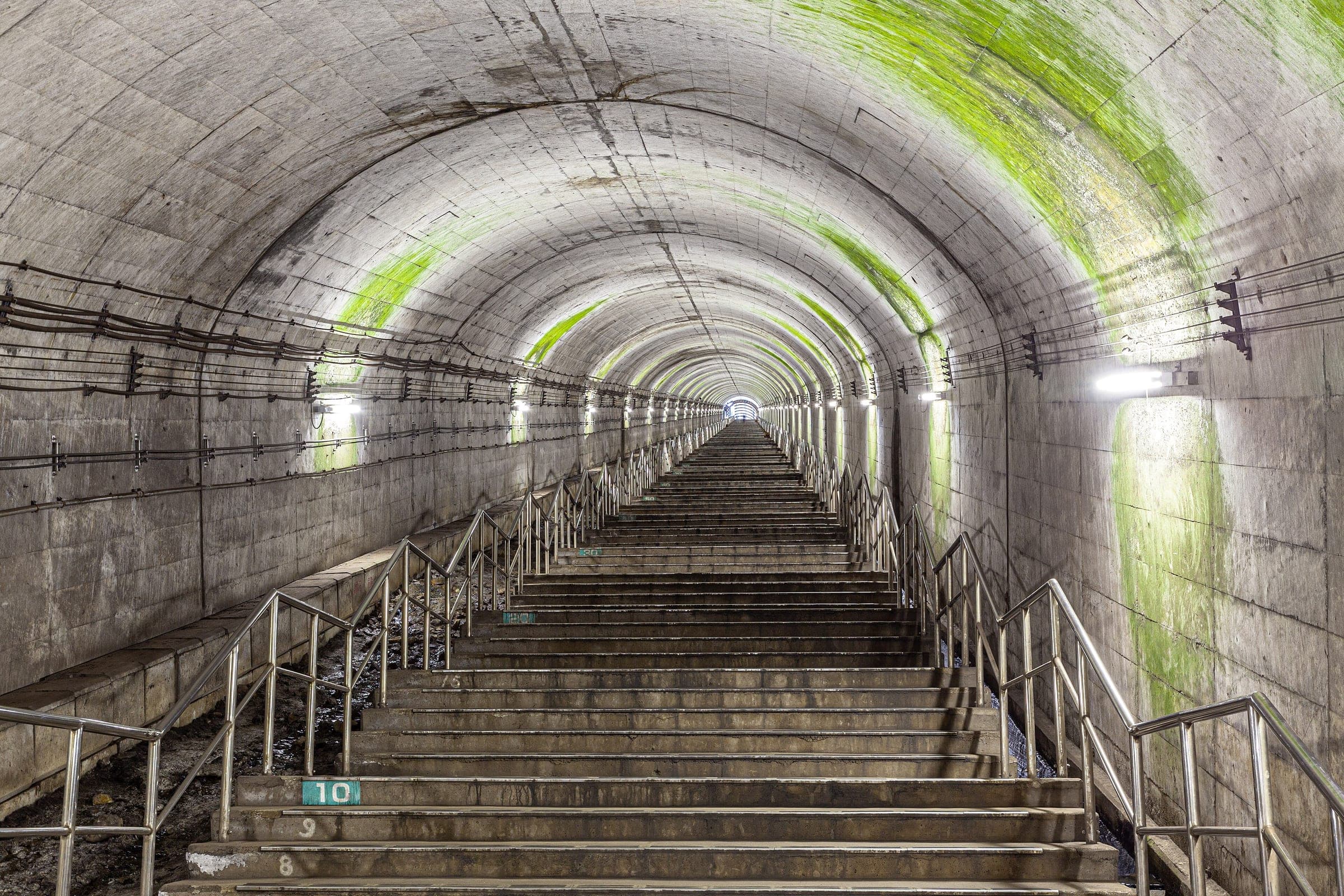 The long lit staircase rises from the tunnel platform at Doai Station in Minakami