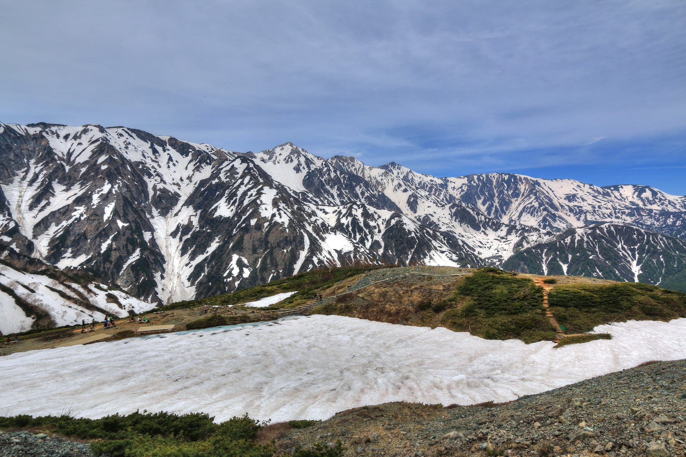 Late snow still covers the Happo-ike basin in May, with the Hakuba Sanzan streaked white beyond.