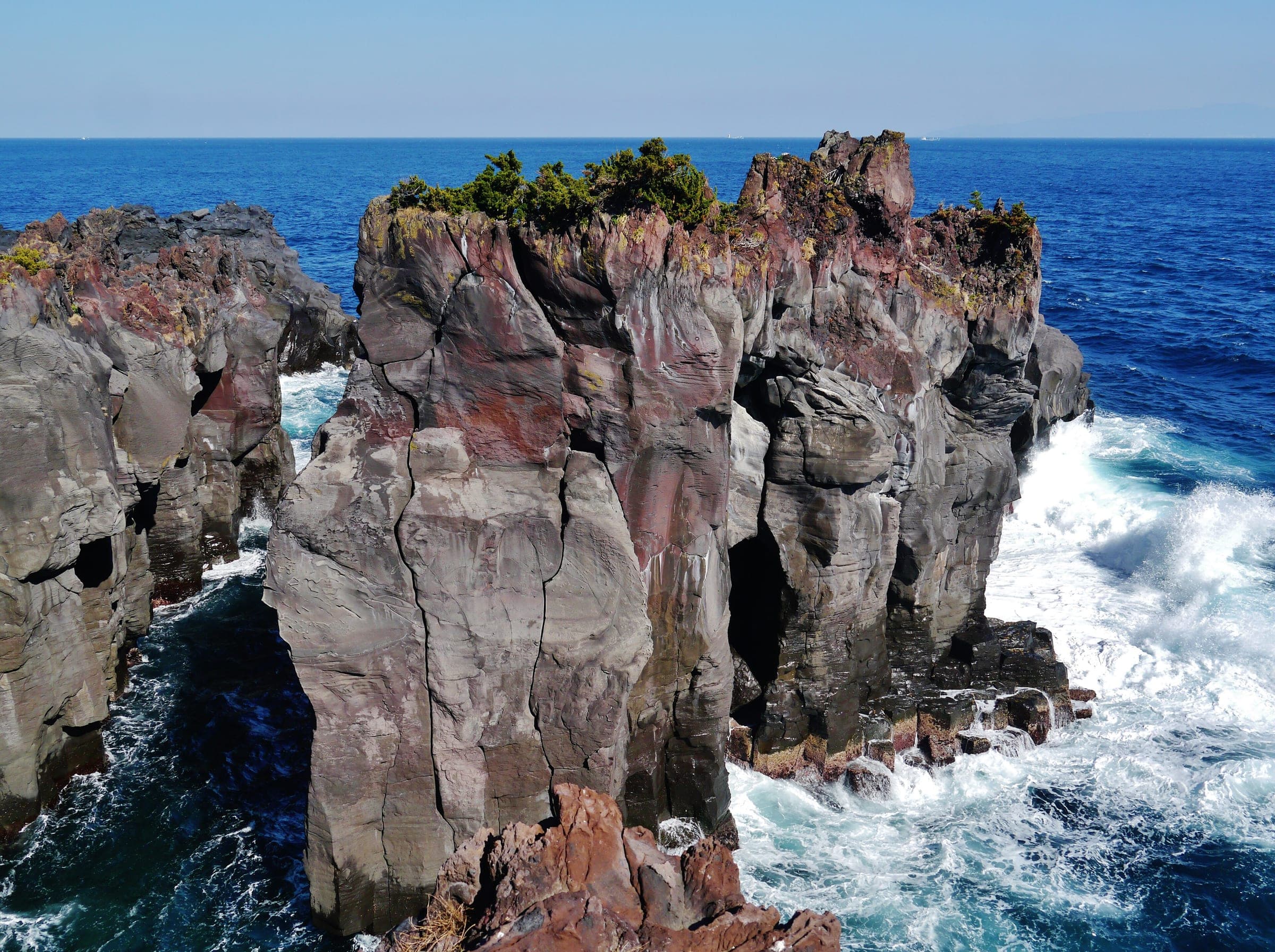 Surf breaks around a stack of columnar lava on the Jogasaki Coast in Ito.
