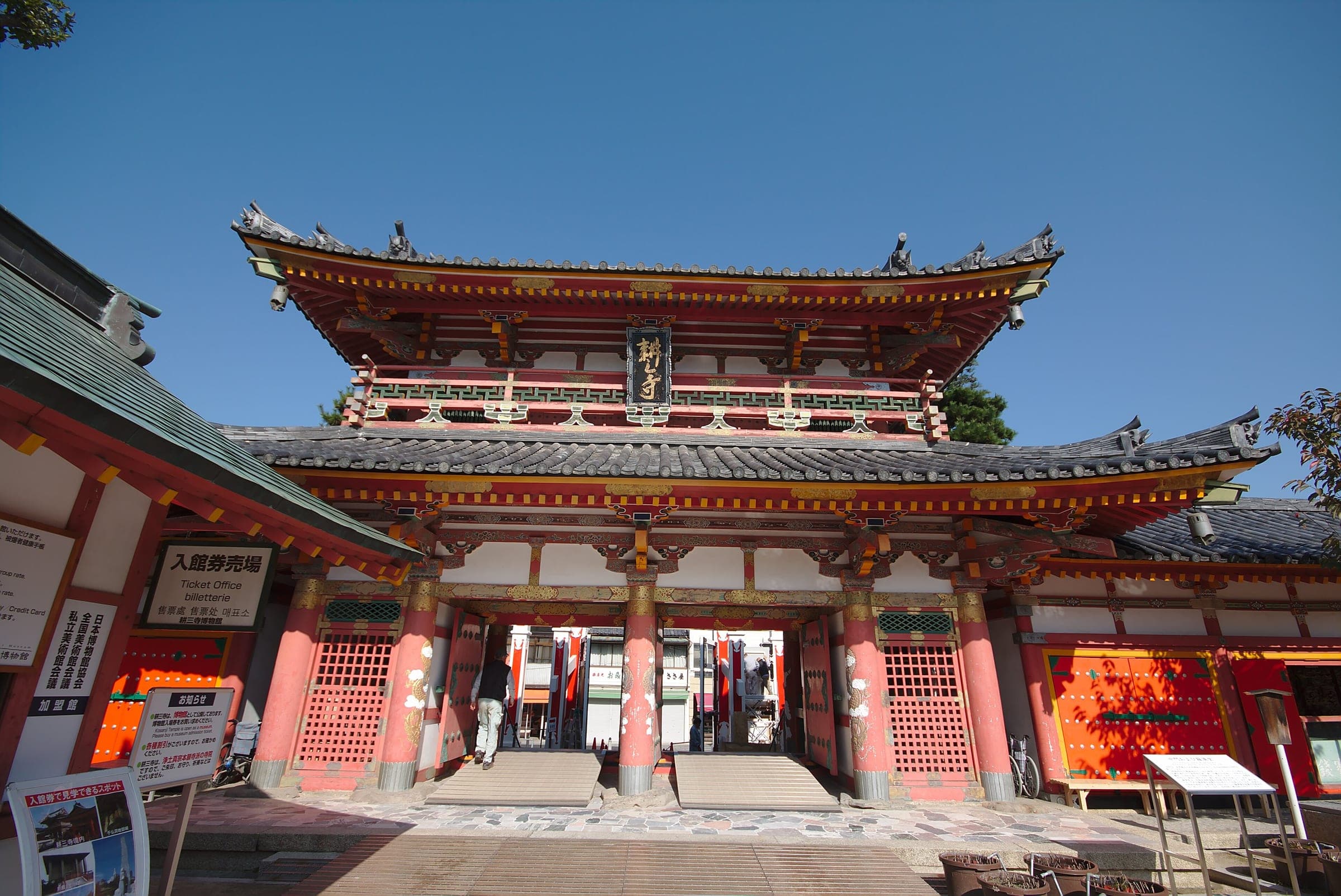 The vermilion main gate of Kosanji Temple stands under a clear sky in Setoda on Ikuchijima.