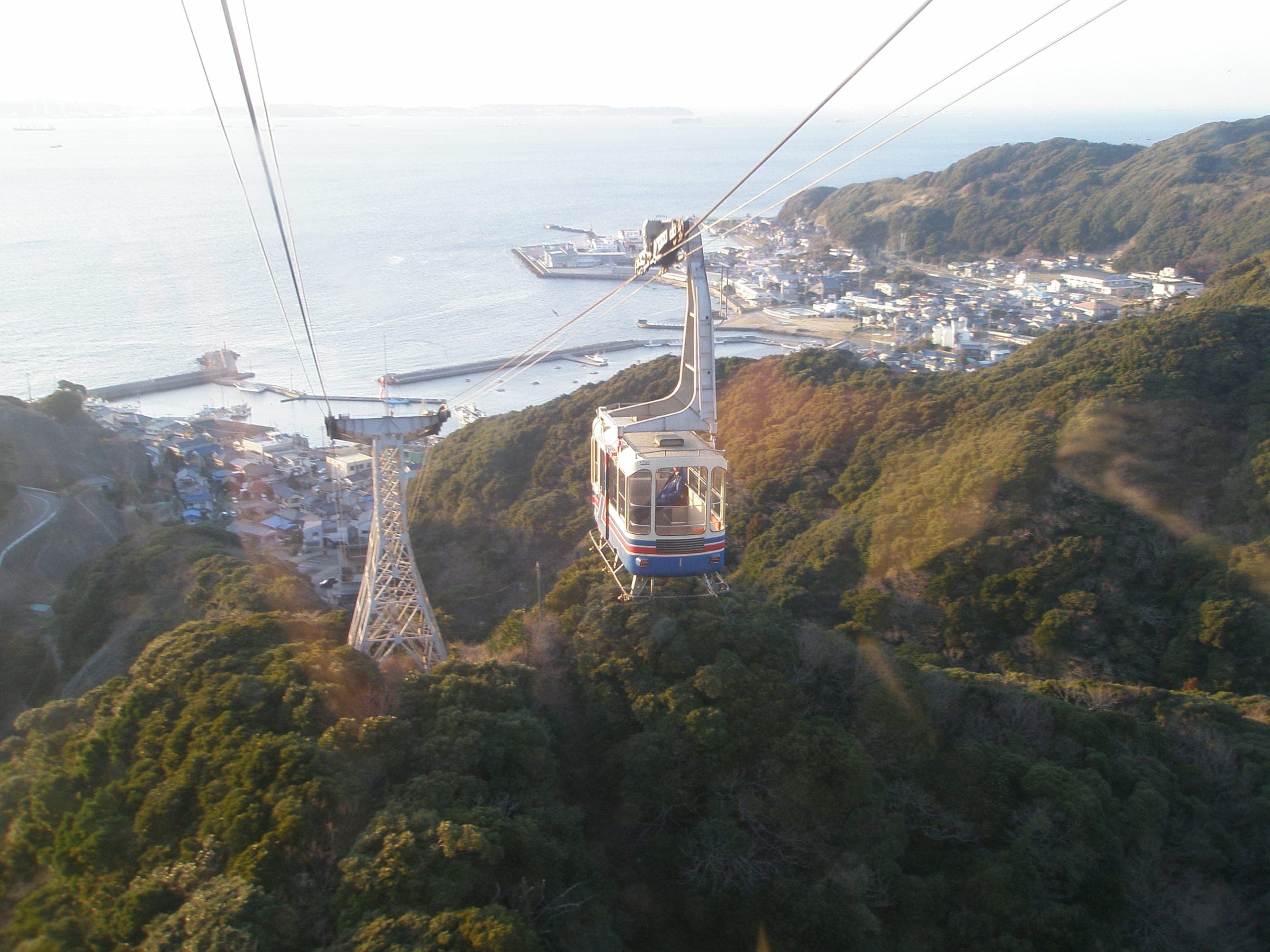 A Nokogiriyama Ropeway car climbs above Kanaya port and Tokyo Bay toward the summit station.
