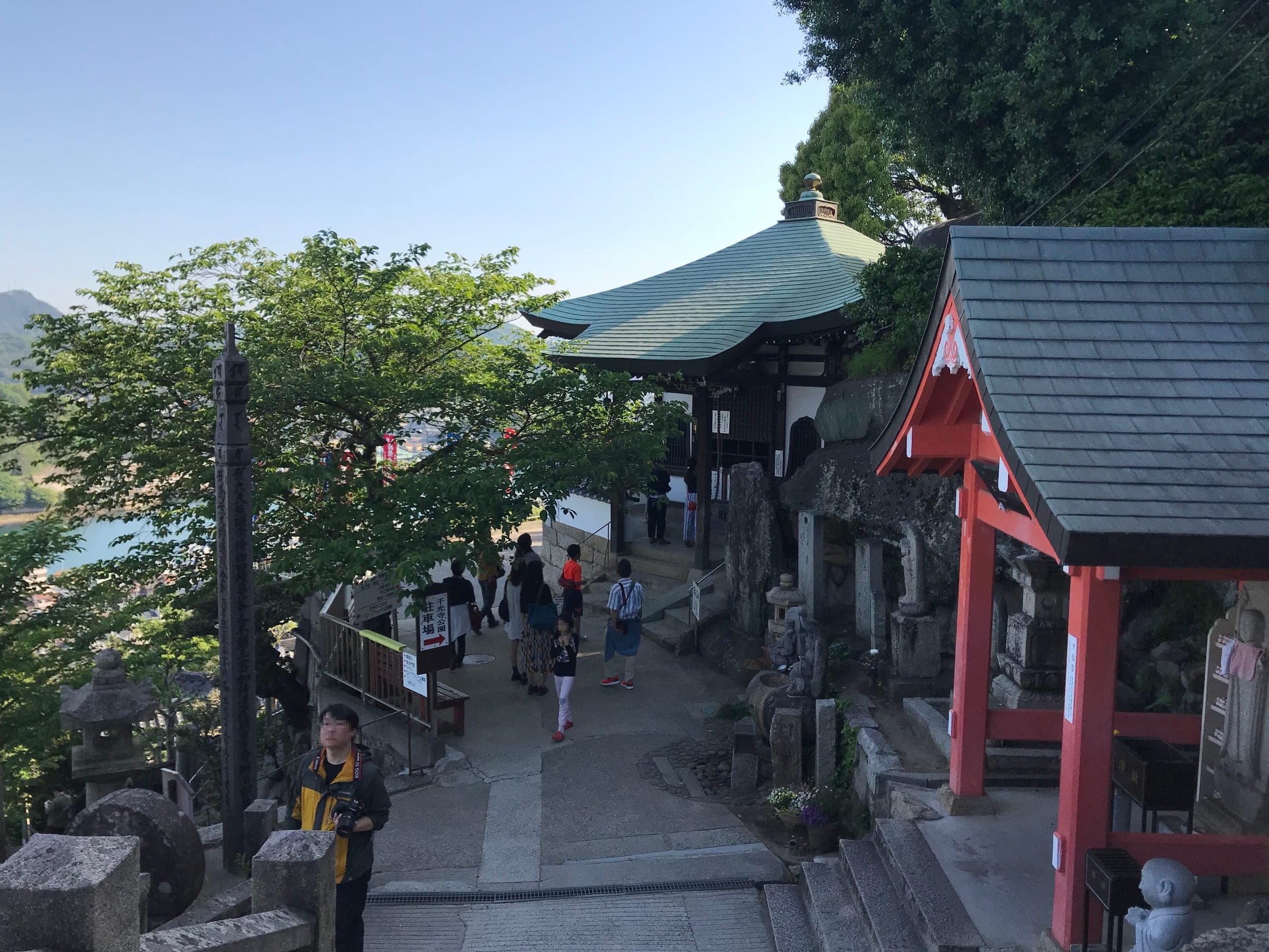 Visitors climb past the Kannondo and Daisendo halls of Senkoji Temple on the hill above Onomichi.