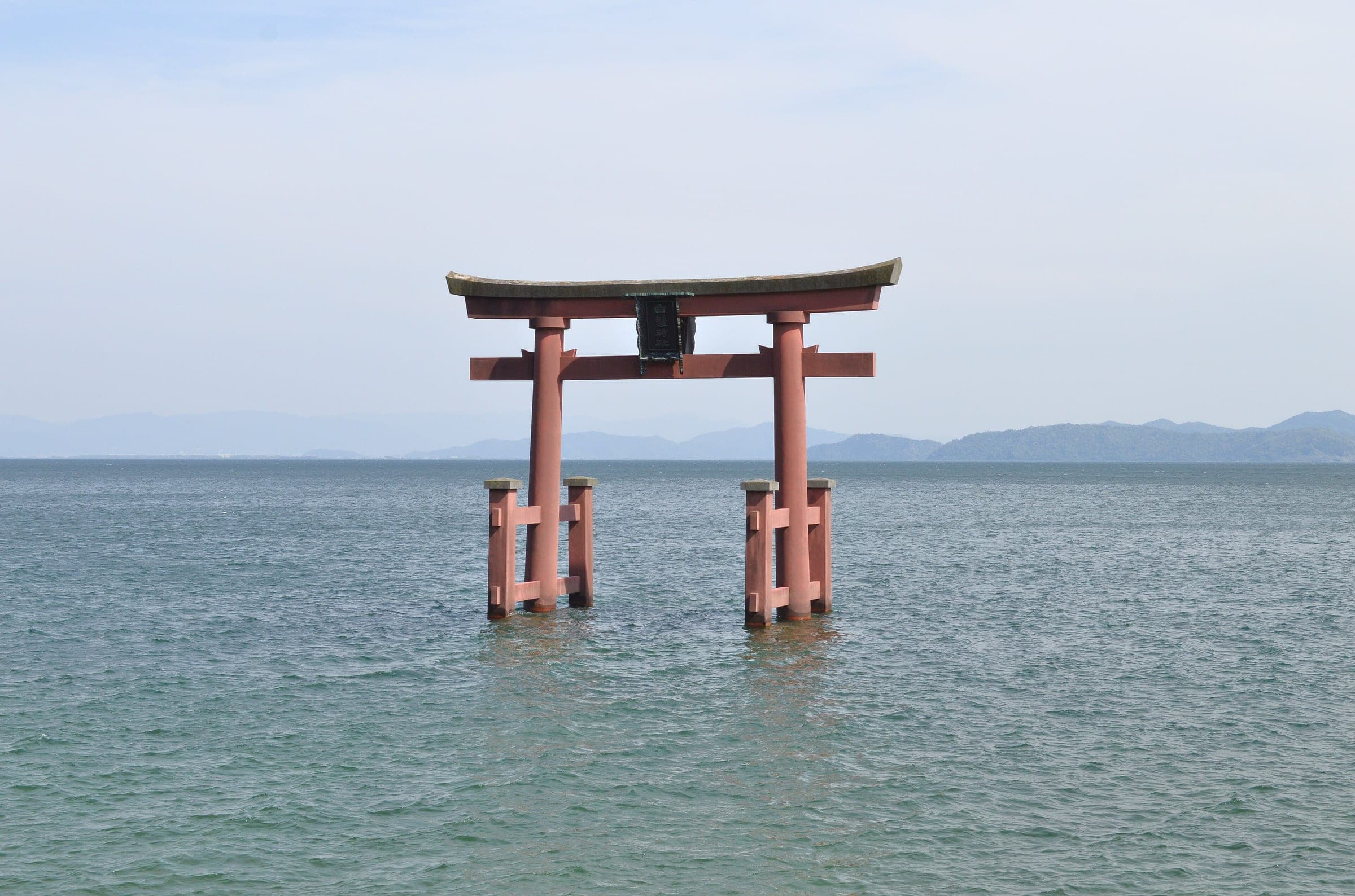The vermilion torii of Shirahige Shrine stands in the shallows of Lake Biwa off Takashima