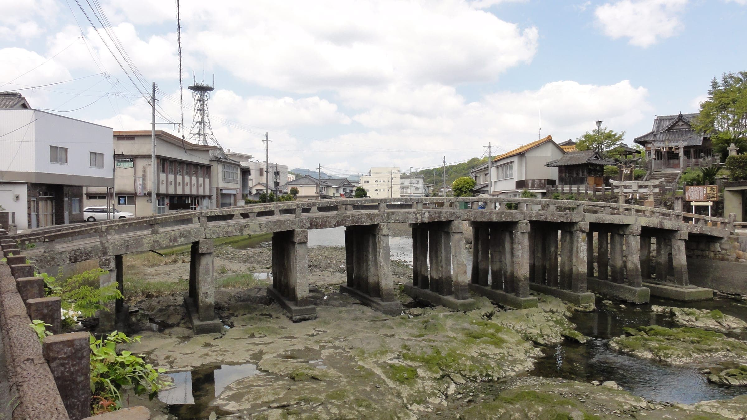 The stone piers of Gion Bridge carry its flat deck across the Machiyamaguchi River in Hondo.