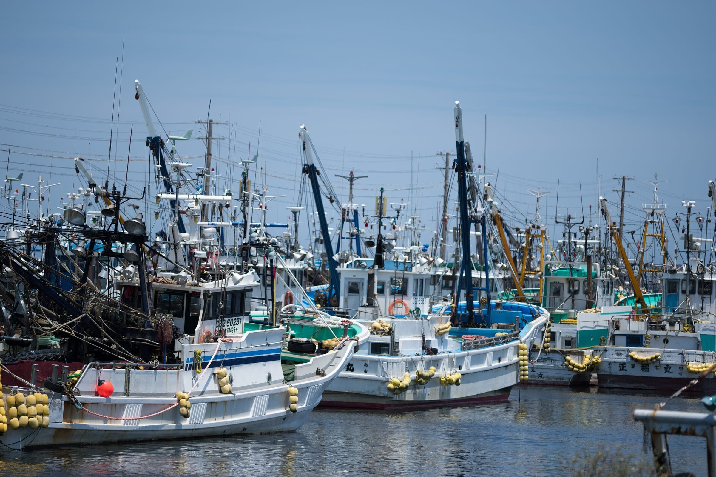 Fishing boats with their cranes and floats crowd the quay at Choshi port in June.