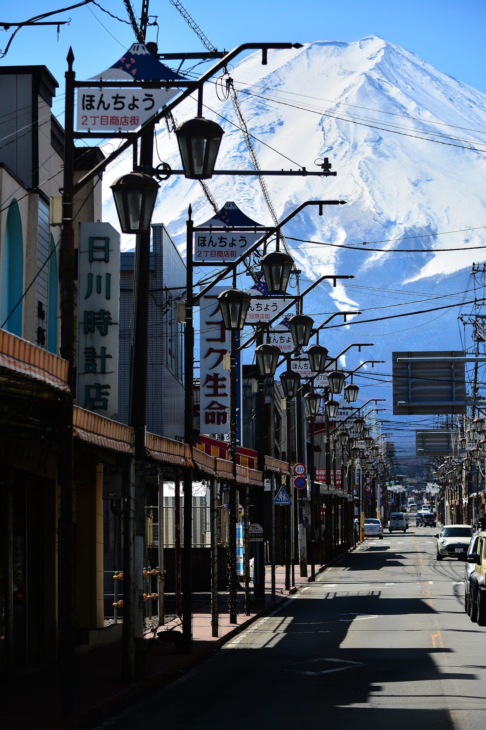 Snow-covered Mt. Fuji fills the sky at the end of the Honcho shopping street in Fujiyoshida.