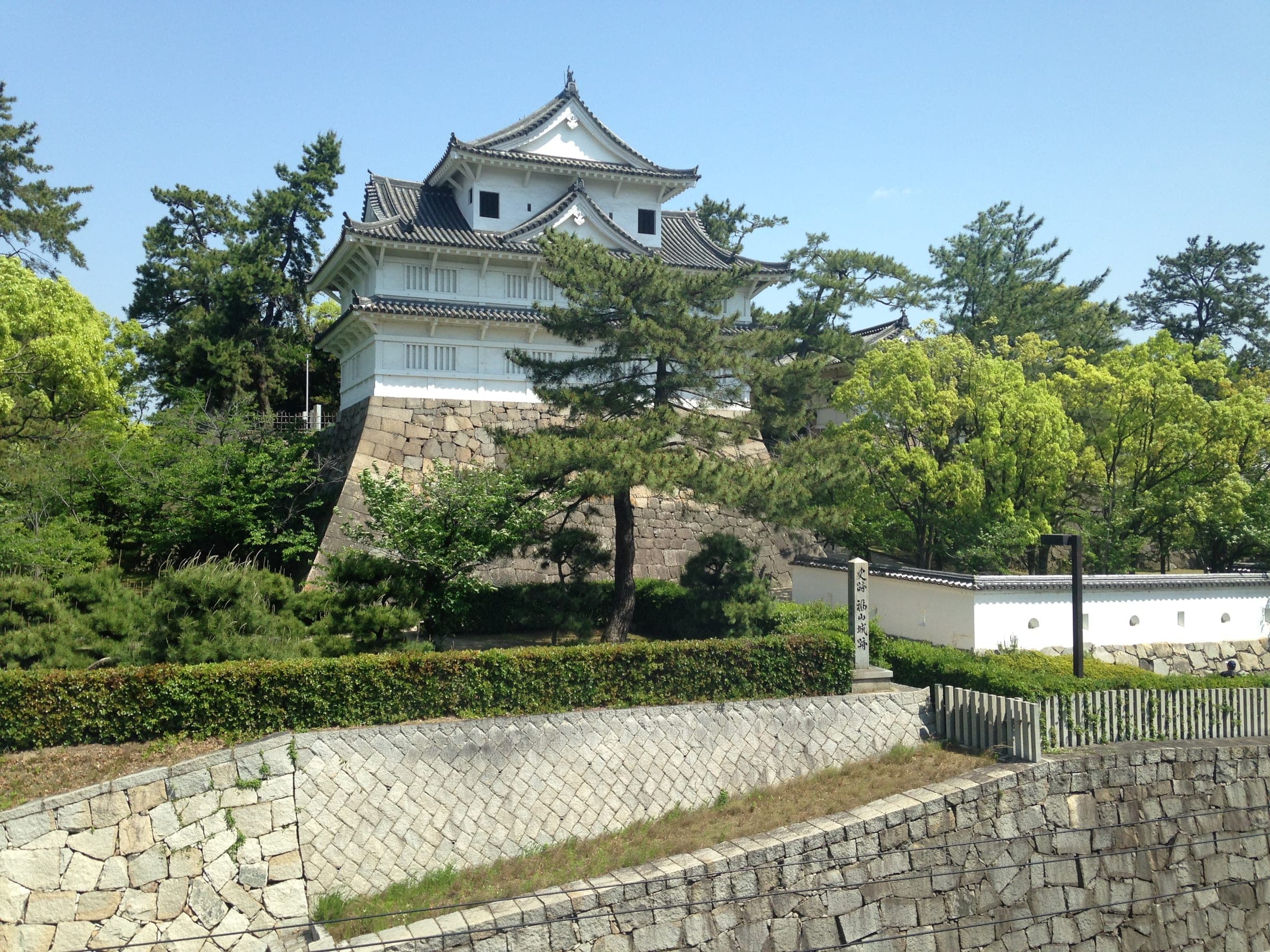The Fushimi Turret of Fukuyama Castle stands on stone walls beside Fukuyama Station.