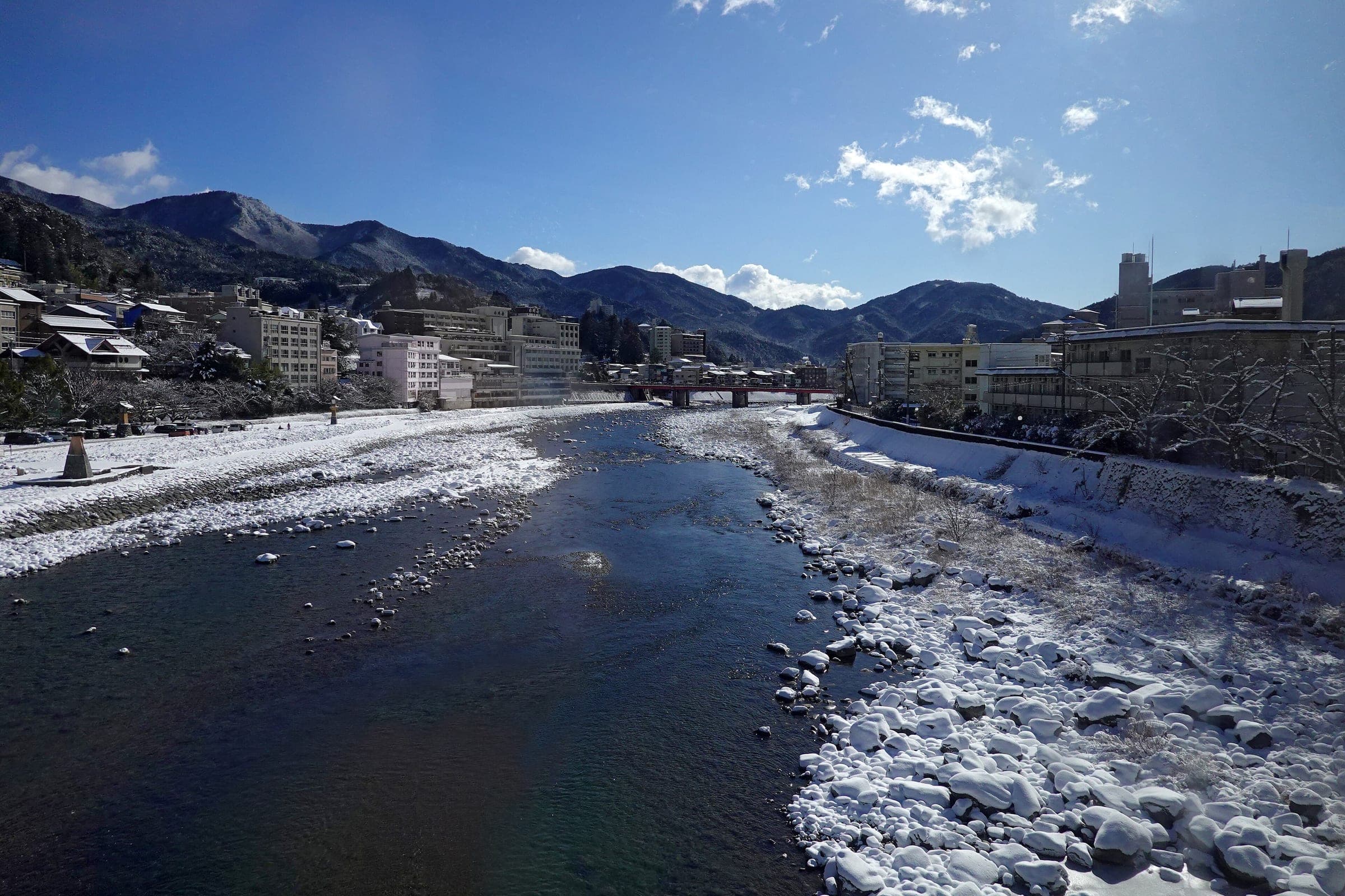 Snow lines the banks of the Hida River as it flows past the inns of Gero Onsen in January