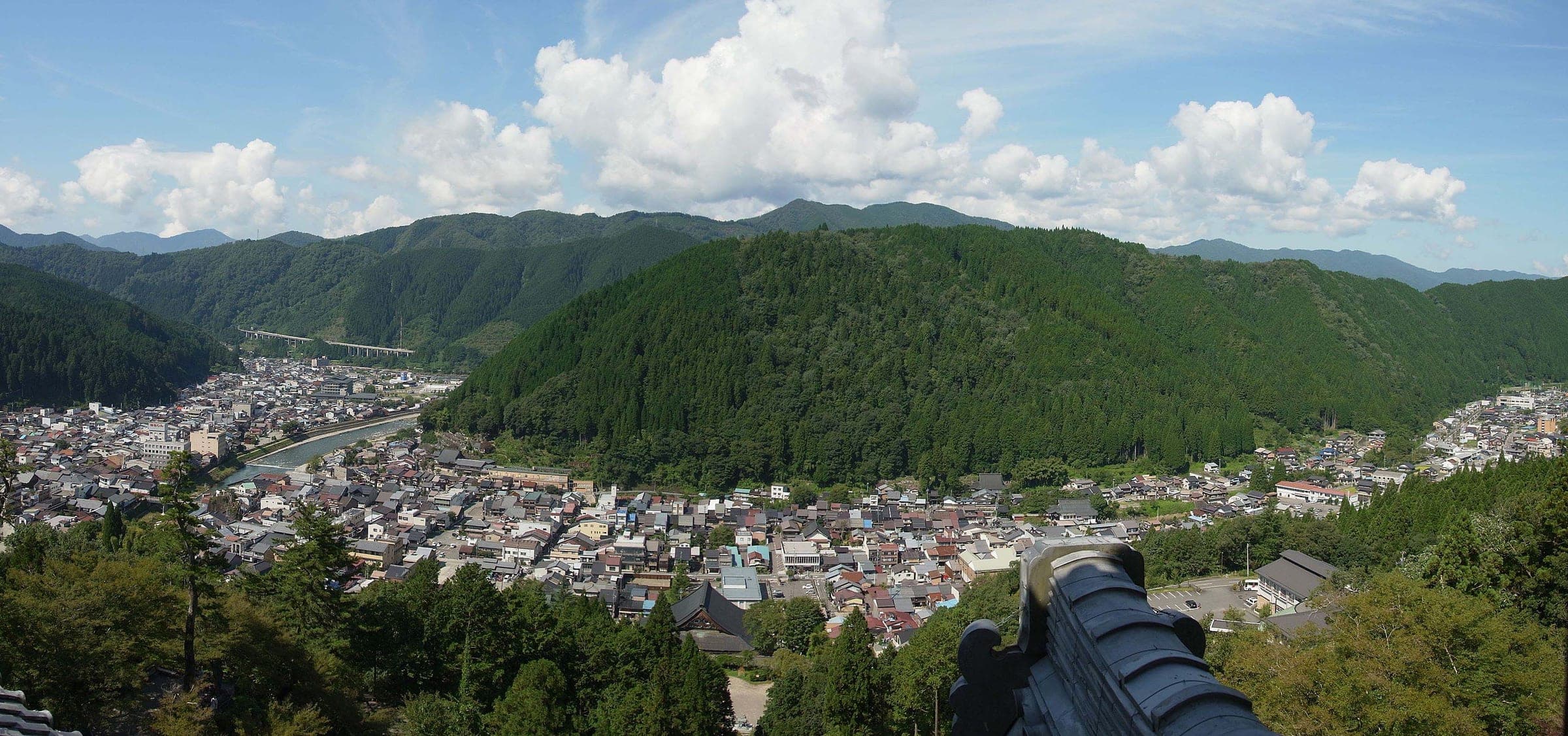 Gujo-Hachiman's rooftops fill the valley between wooded hills in the view from the castle keep