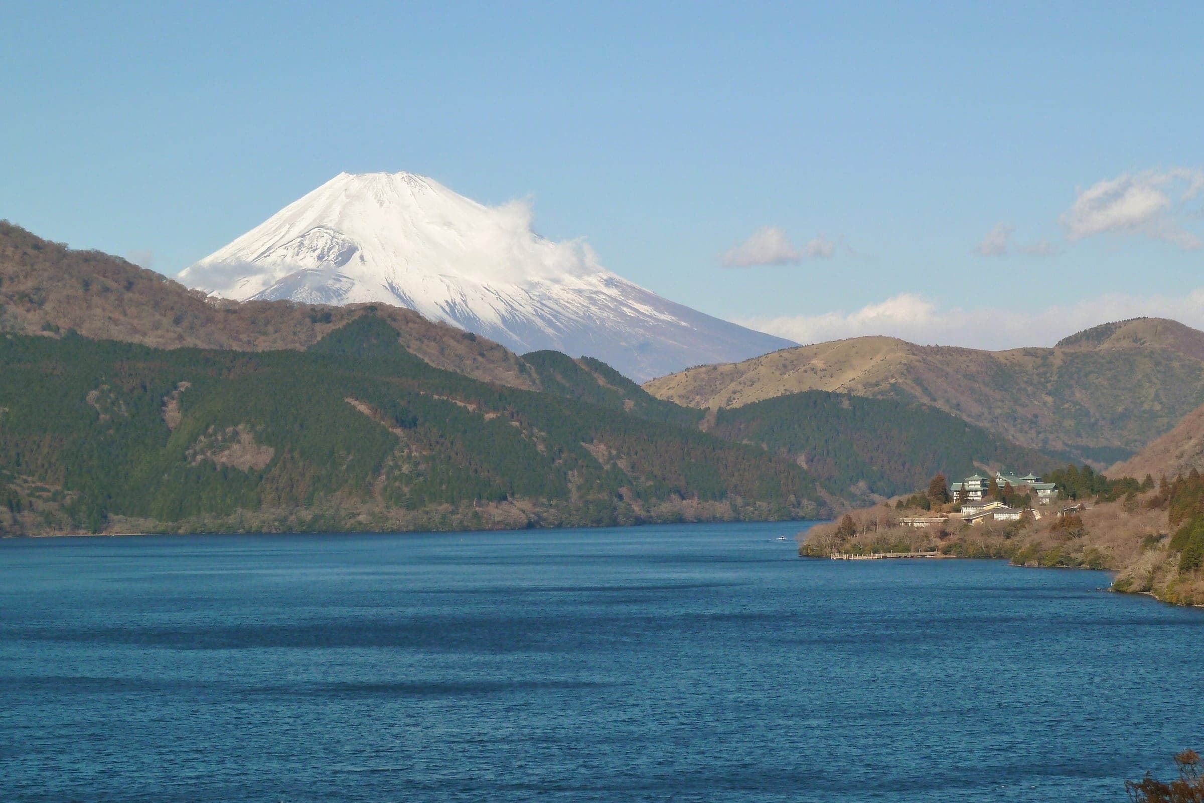 From Onshi Hakone Park, snow-covered Mt. Fuji rises over Lake Ashi on a January day.