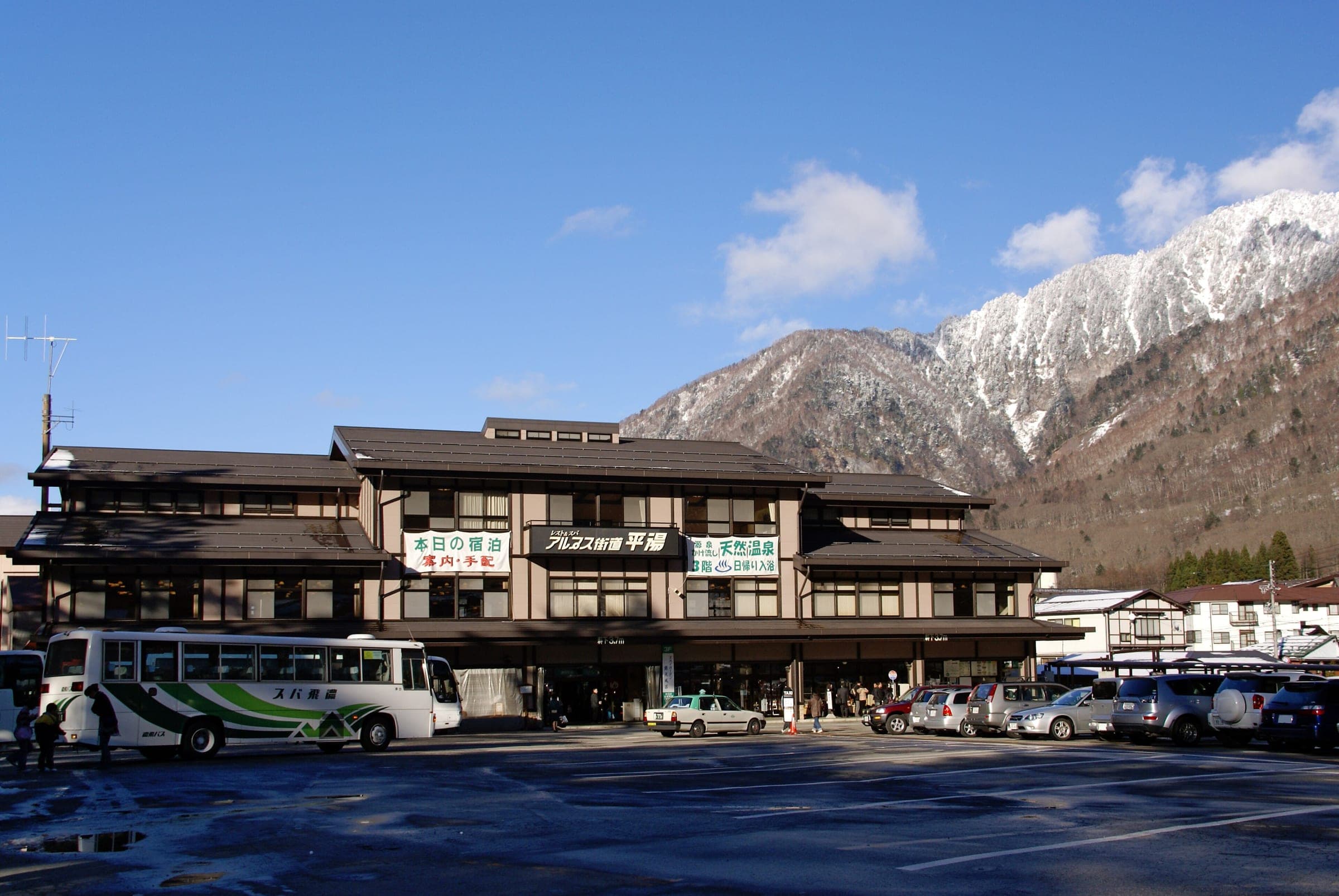 Hirayu Onsen bus terminal sits below a snow-capped peak on a clear November day