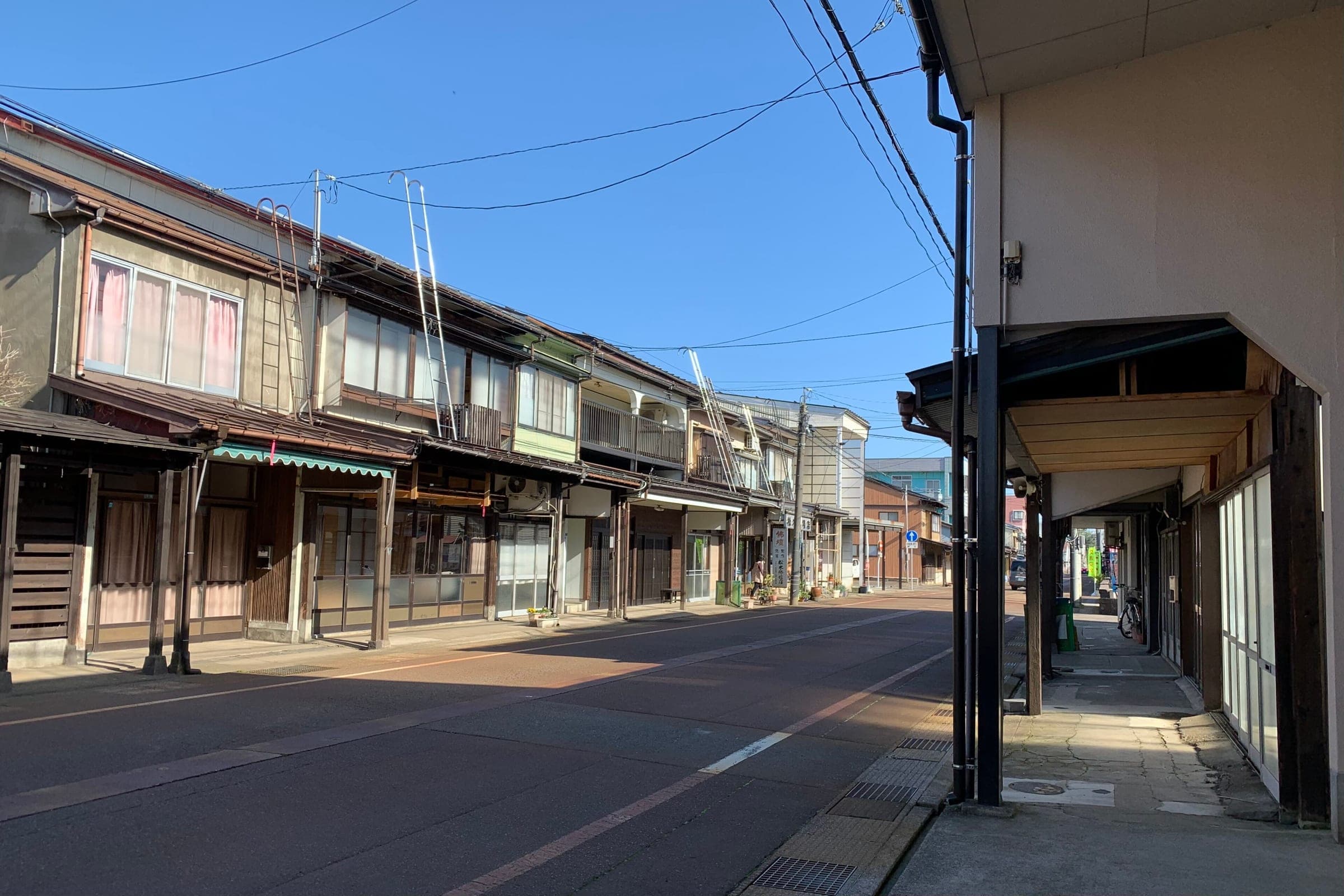 Wooden gangi snow arcades shade the pavements of Omachi street in Takada, Joetsu
