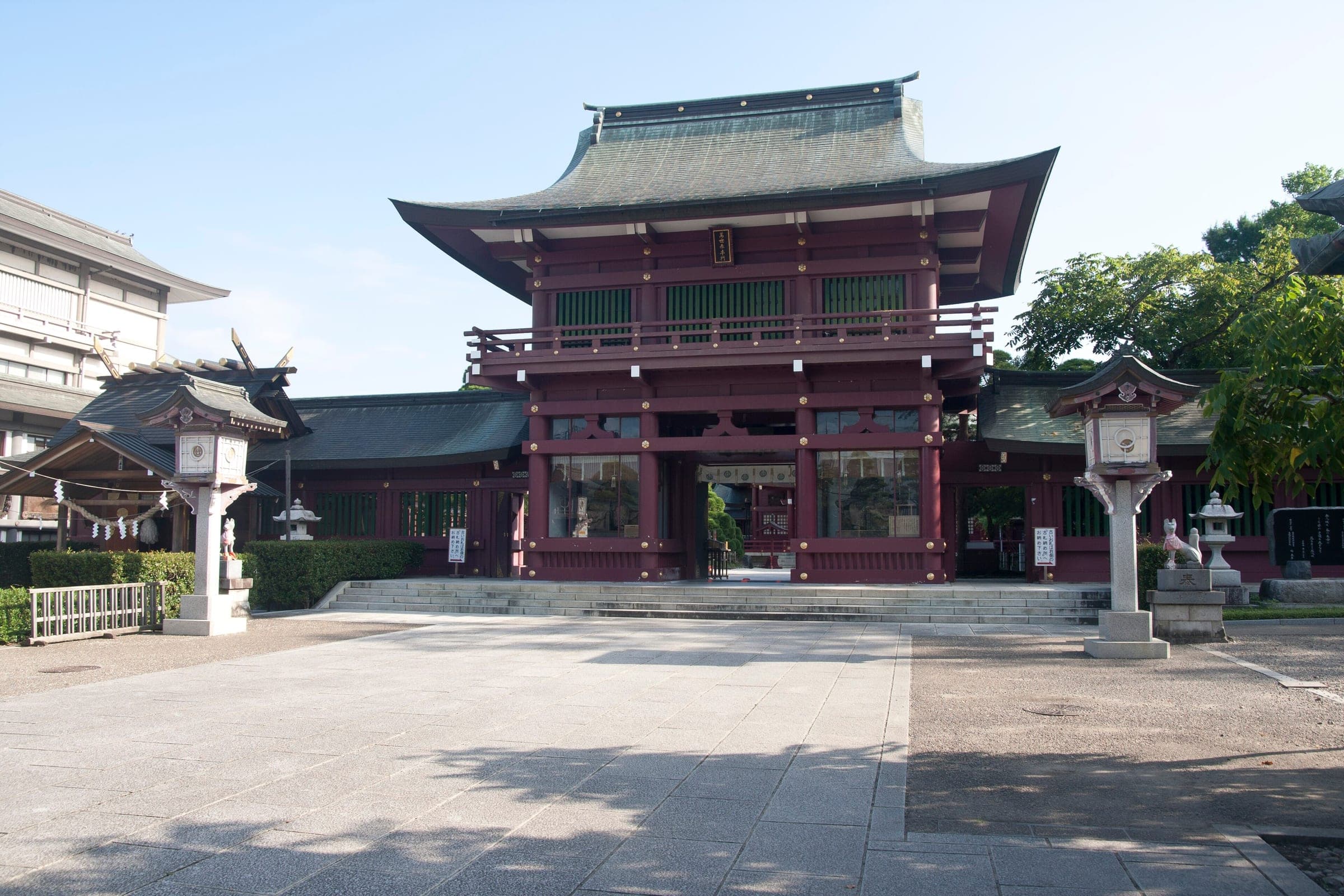 The two-storey Romon gate of Kasama Inari Shrine faces its paved forecourt in Kasama.