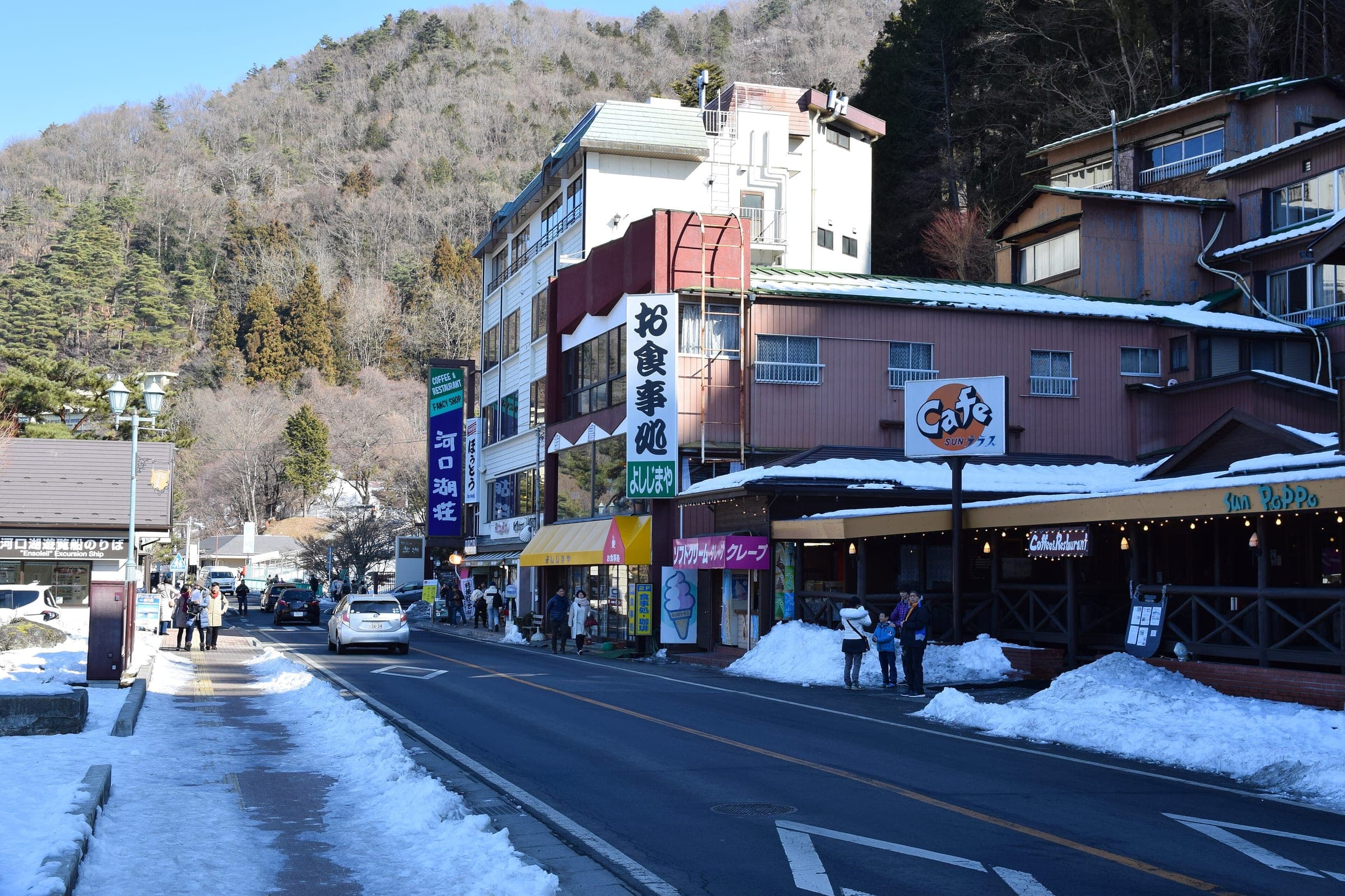 Snow banks line a hotel street in Fujikawaguchiko on a sunny January day.