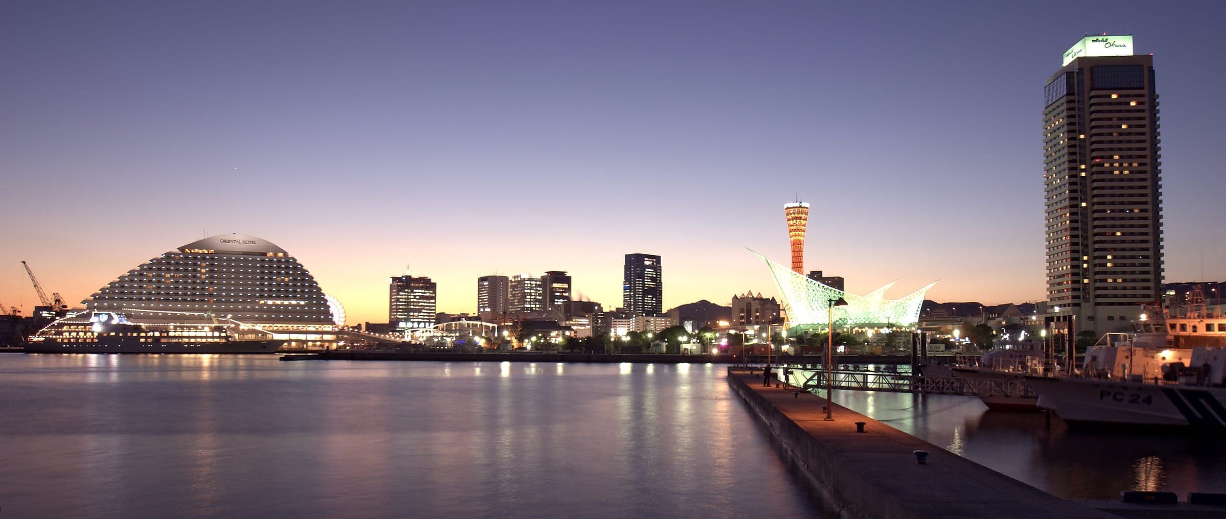 Lights come on around the Port of Kobe as the sky fades to violet over Harborland