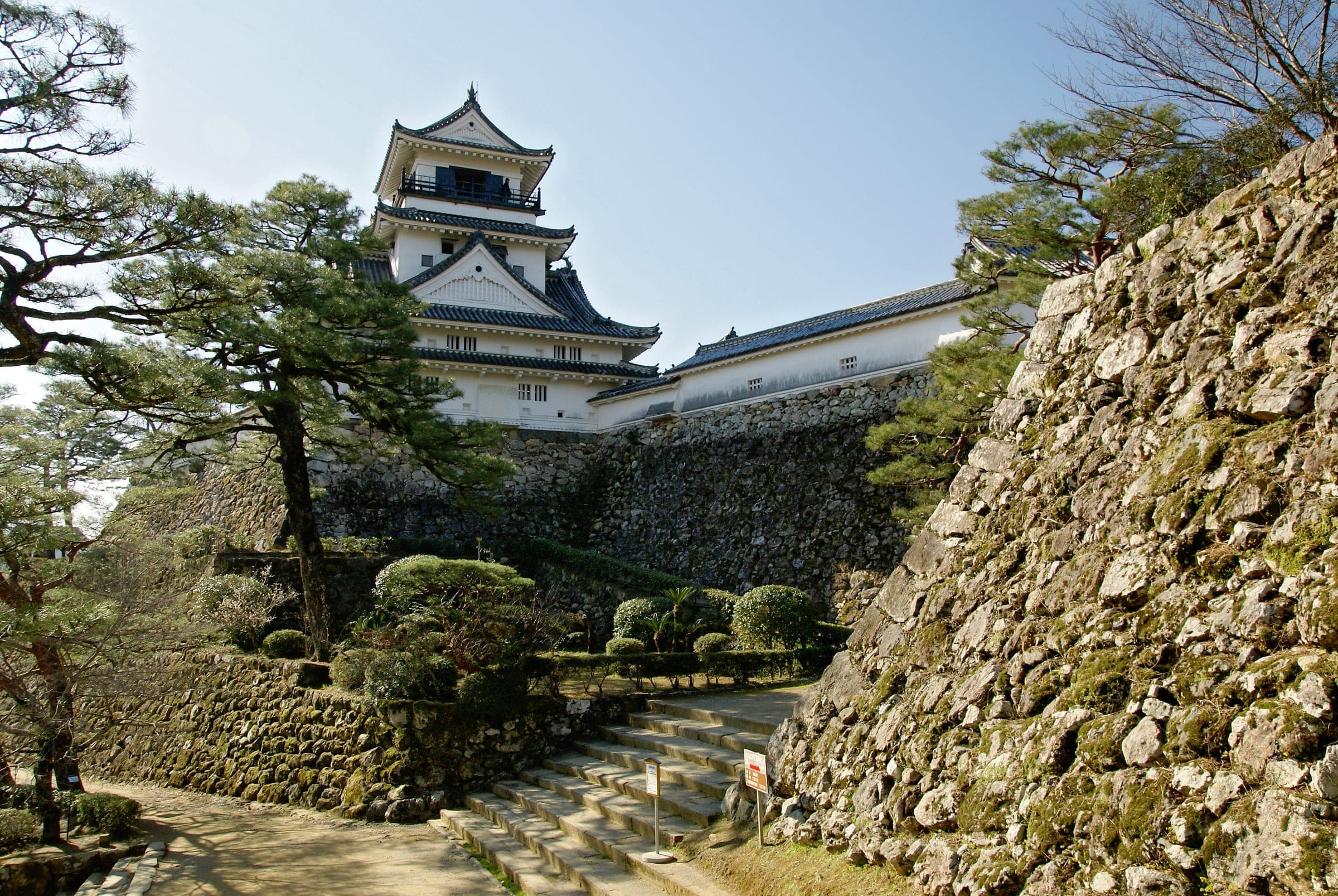 The keep of Kochi Castle stands above mossy stone walls and pines on the castle hill.