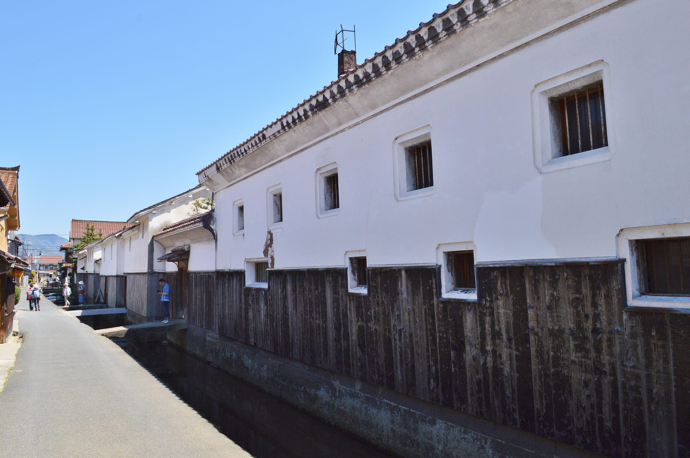 White-plastered storehouses with dark timber bases line the canal in Kurayoshi's old quarter