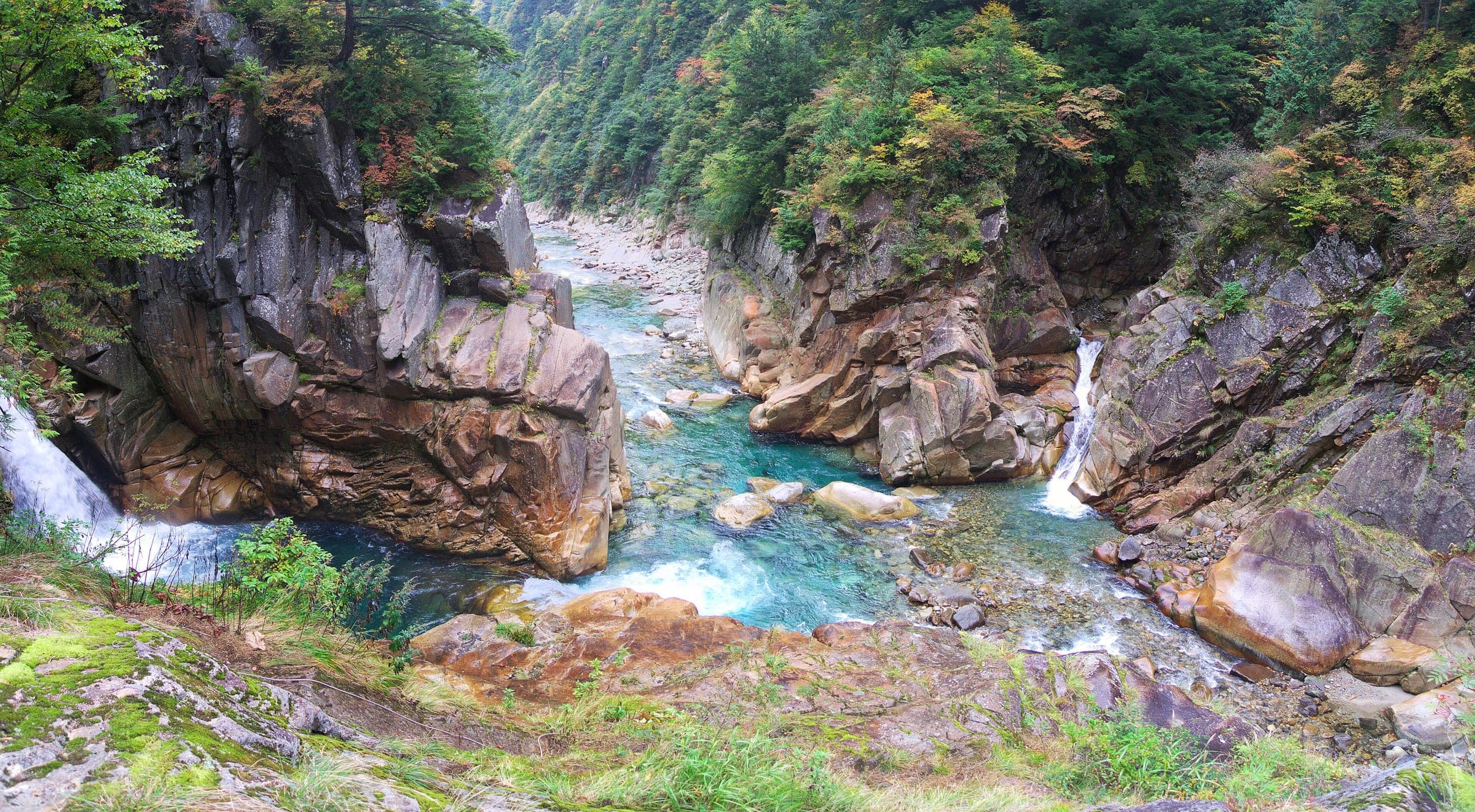 Clear blue water threads between granite walls at Jujikyo deep in the Kurobe Gorge