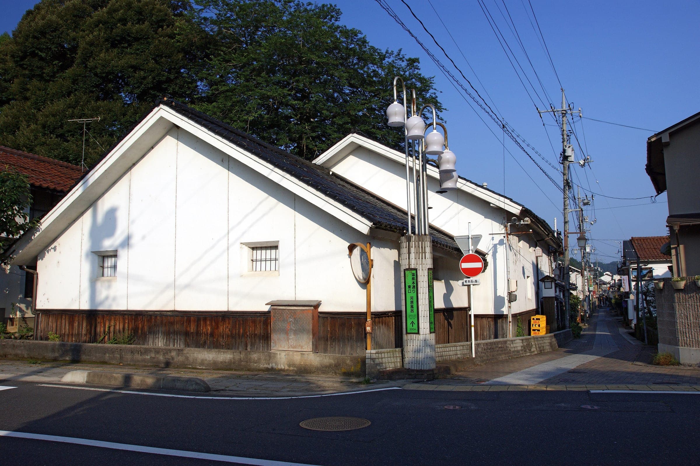 A white-walled storehouse stands on a quiet street corner in Misasa