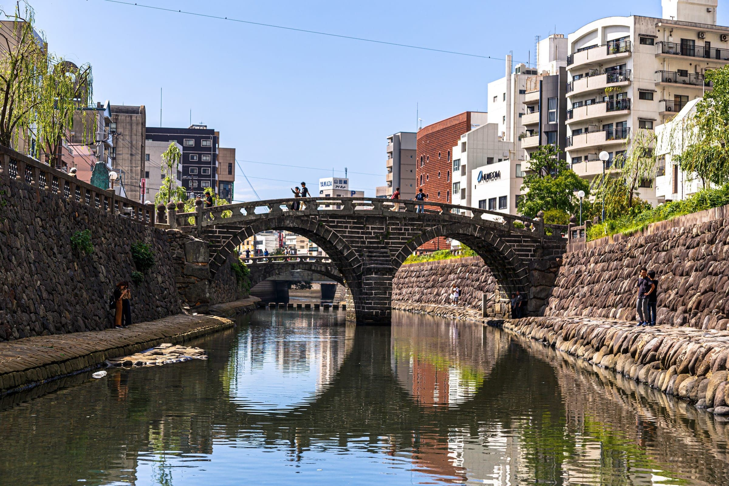 Meganebashi's twin stone arches reflect as a pair of circles in the Nakashima River in central Nagasaki.