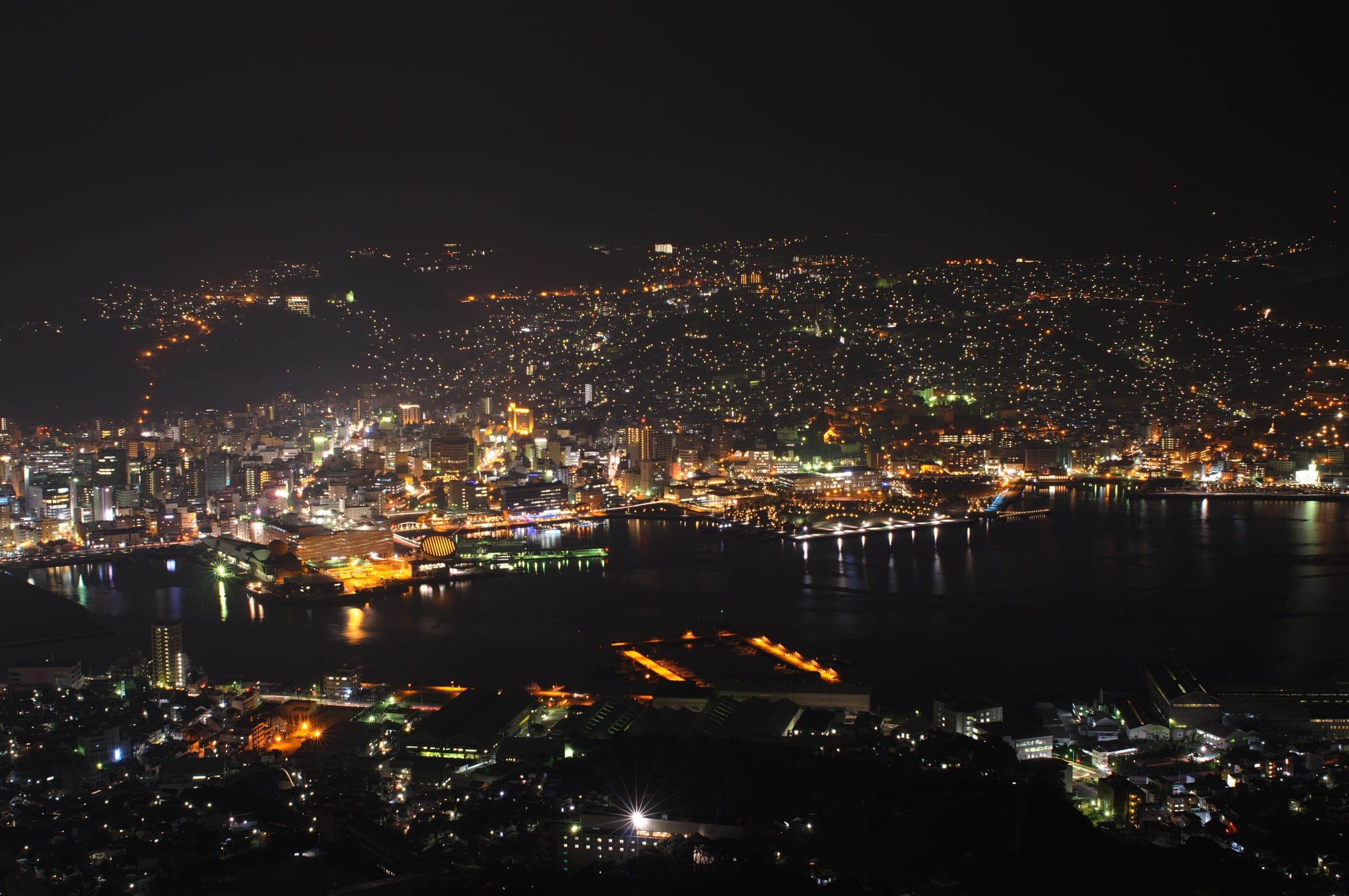 Nagasaki's lights climb the hills around its harbour, seen from Mount Inasa on a January night.