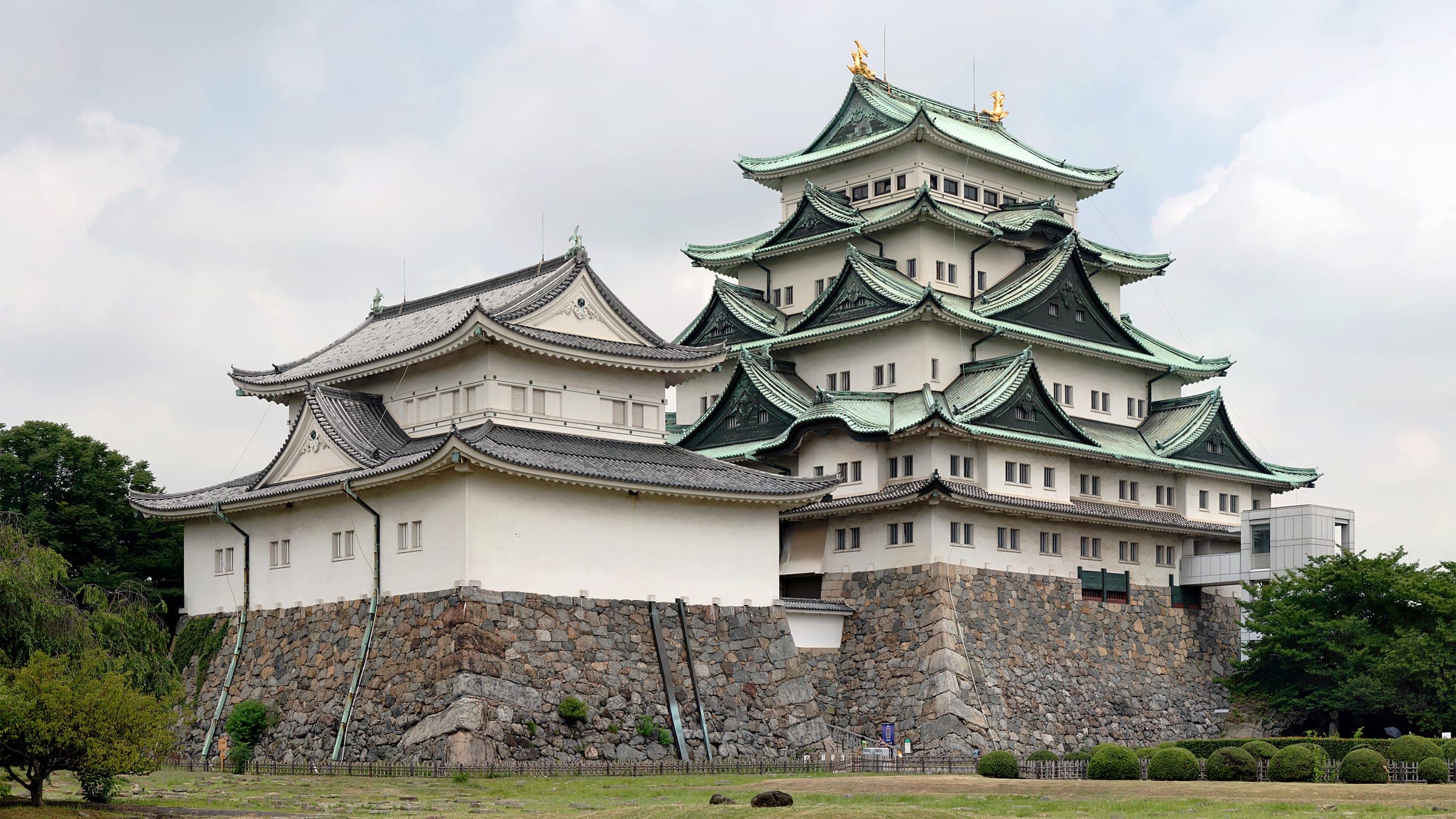 Nagoya Castle's green-roofed keep and smaller tower rise from their stone base