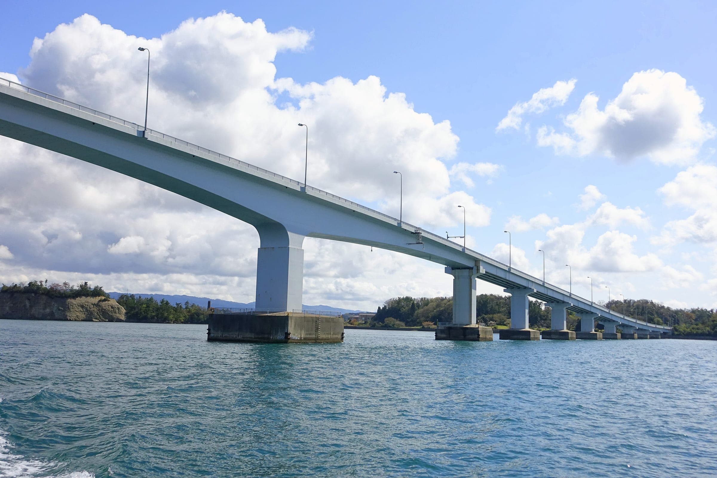 The long concrete Notojima Bridge strides across Nanao Bay toward Noto Island under spring cloud