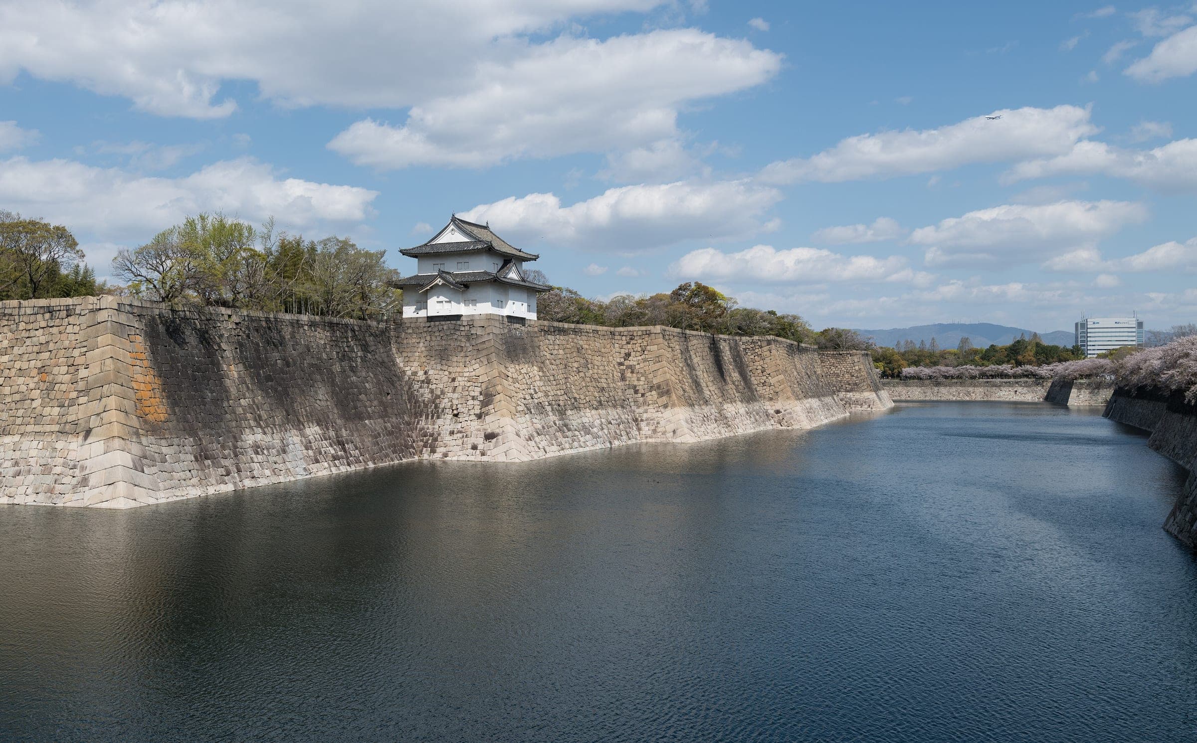 A turret stands on the high stone walls above the south outer moat of Osaka Castle