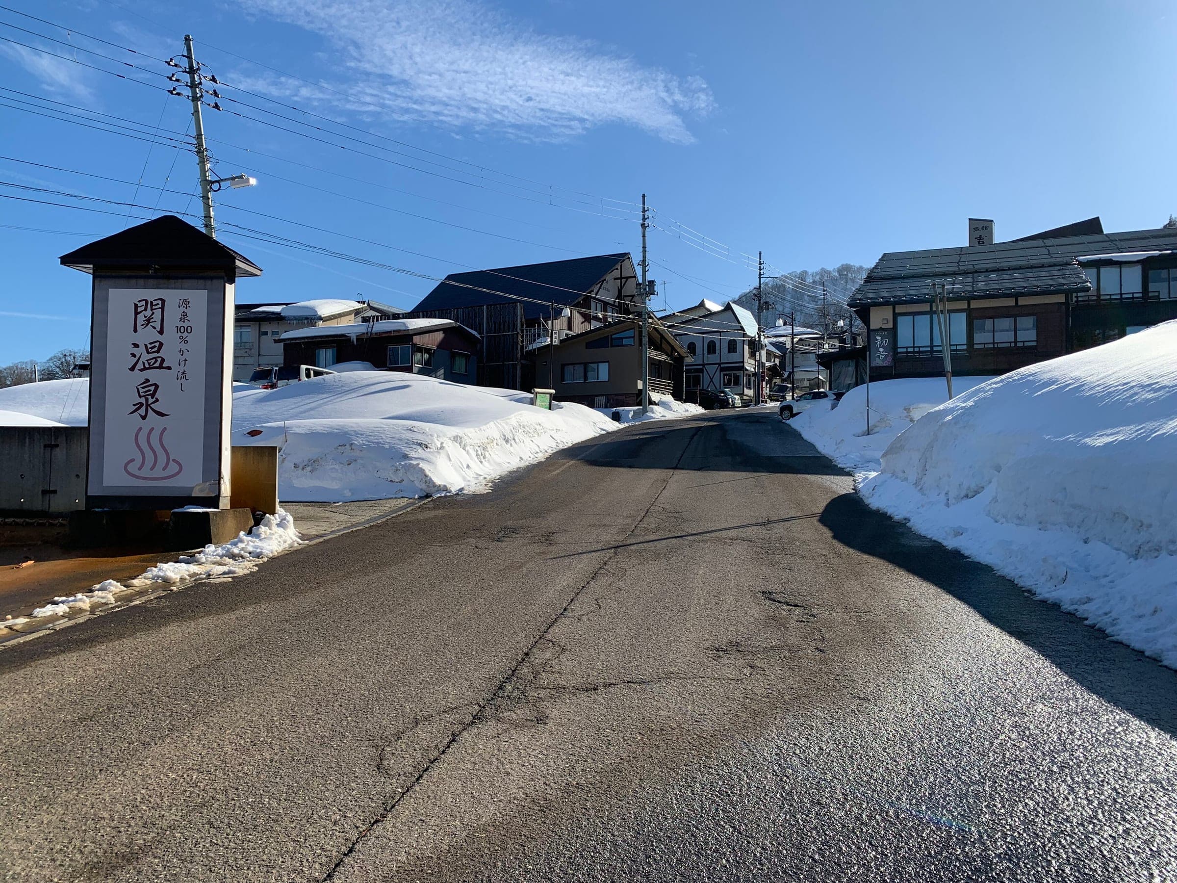 The road into Seki Onsen runs between snowbanks and inns on a clear February day