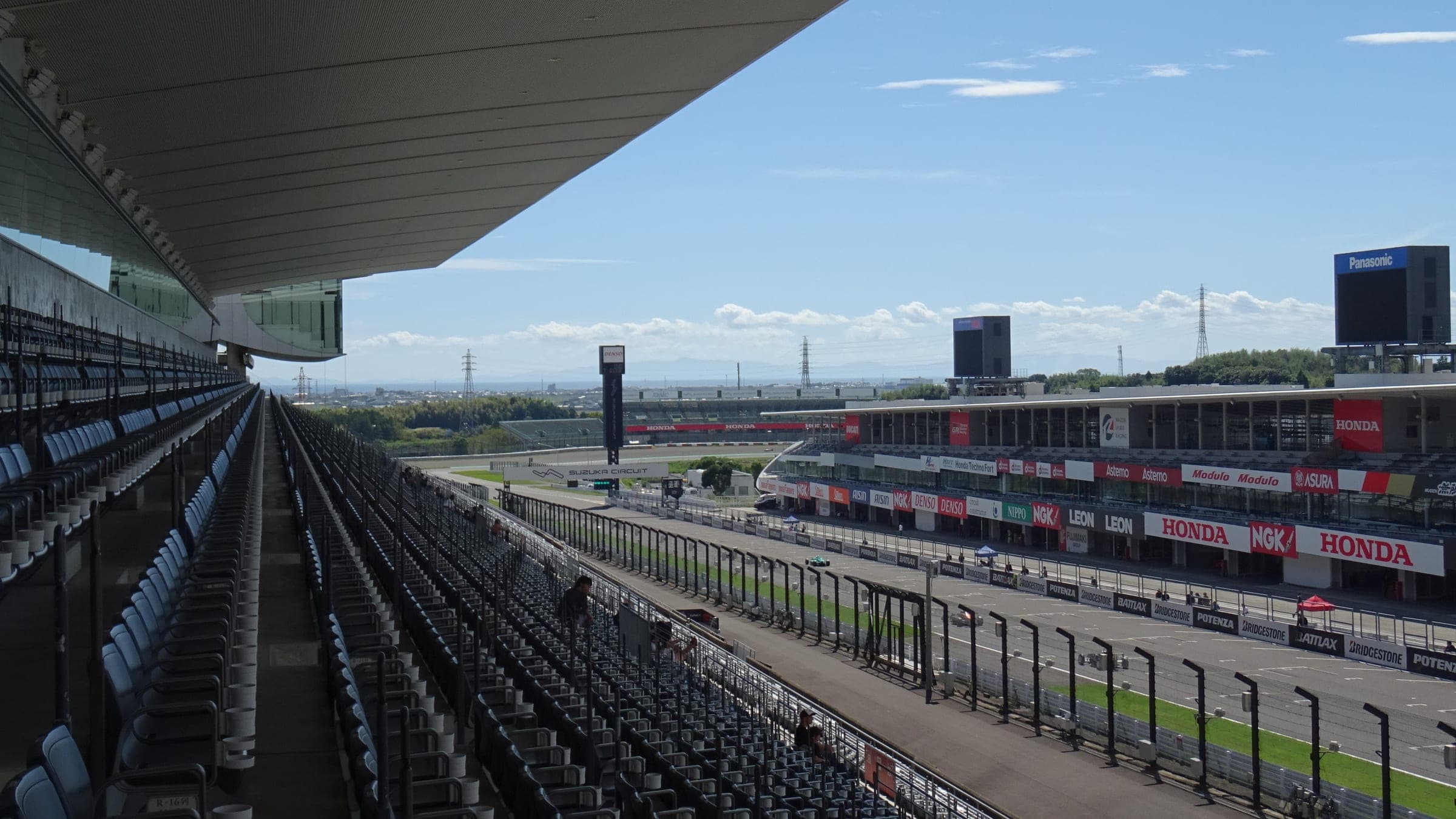 Empty grandstands look down the main straight and pit buildings of Suzuka Circuit