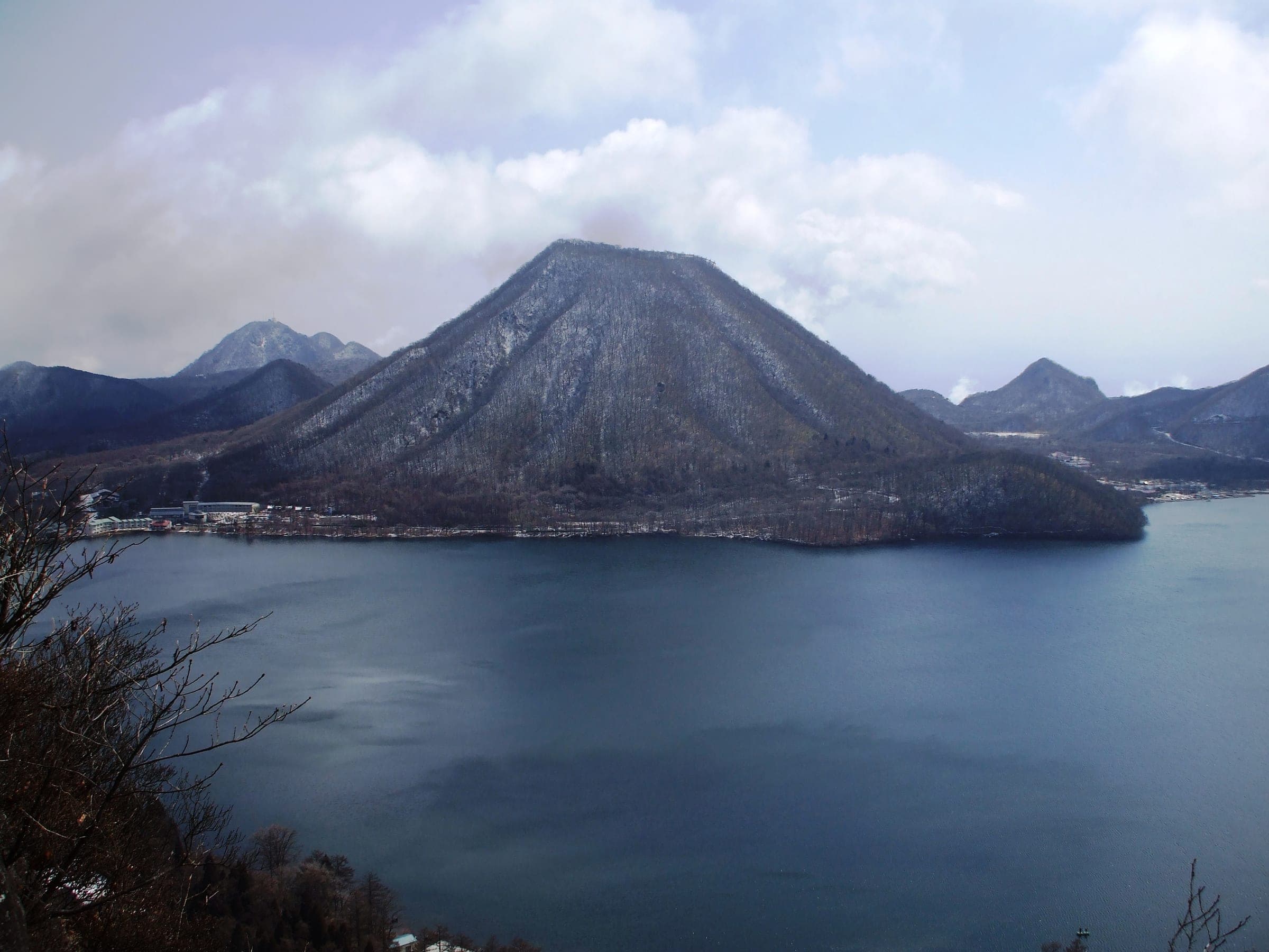 Lake Haruna lies dark and still below the cone of Haruna-Fuji in the hills of Takasaki in March