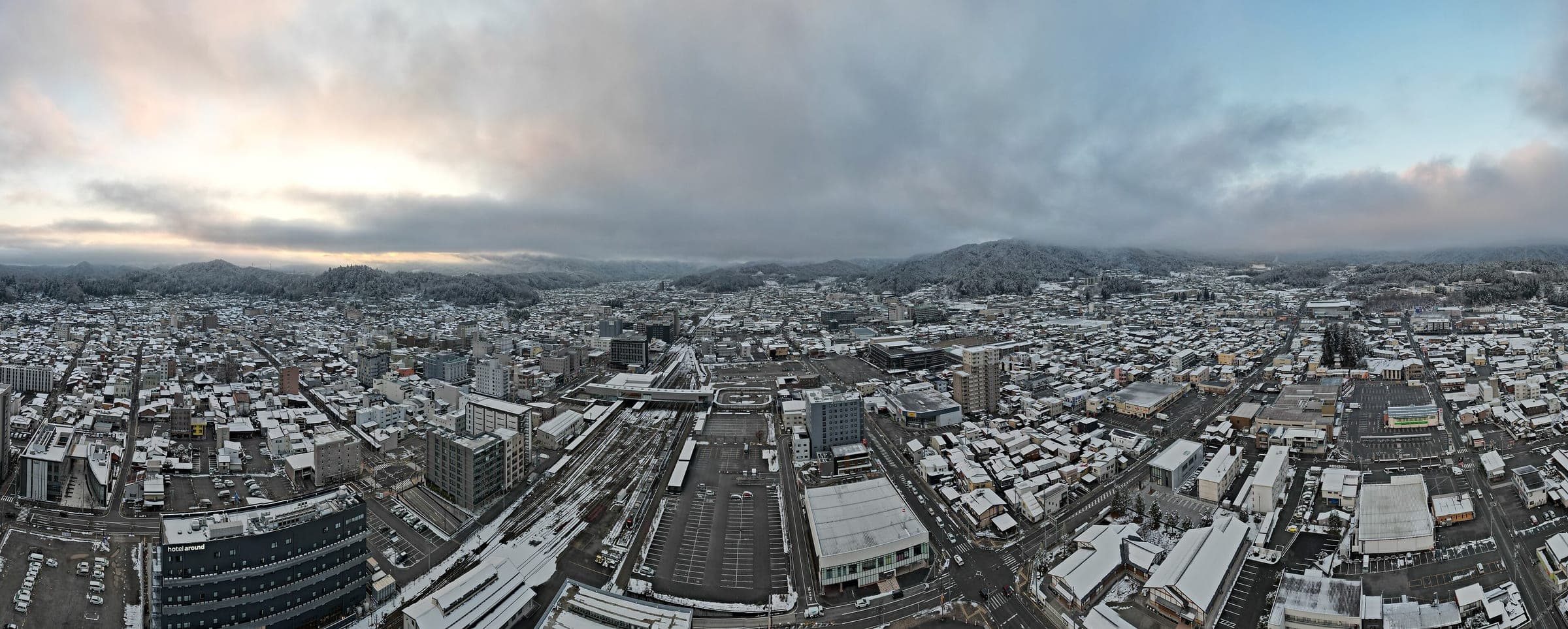 Snow dusts the rooftops of Takayama around the station under a December sky