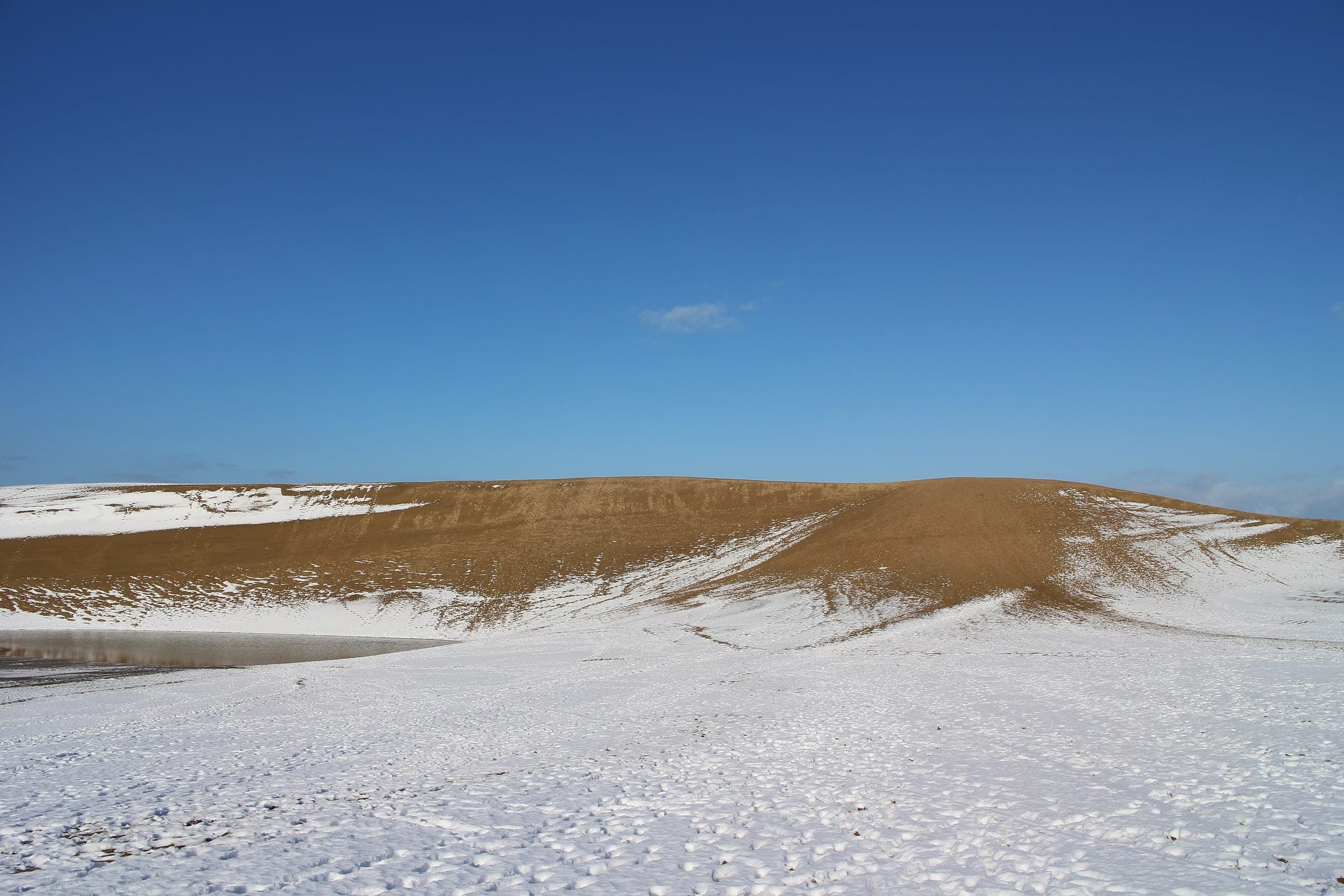 Footprints cross a snow-covered ridge of the Tottori Sand Dunes in late January
