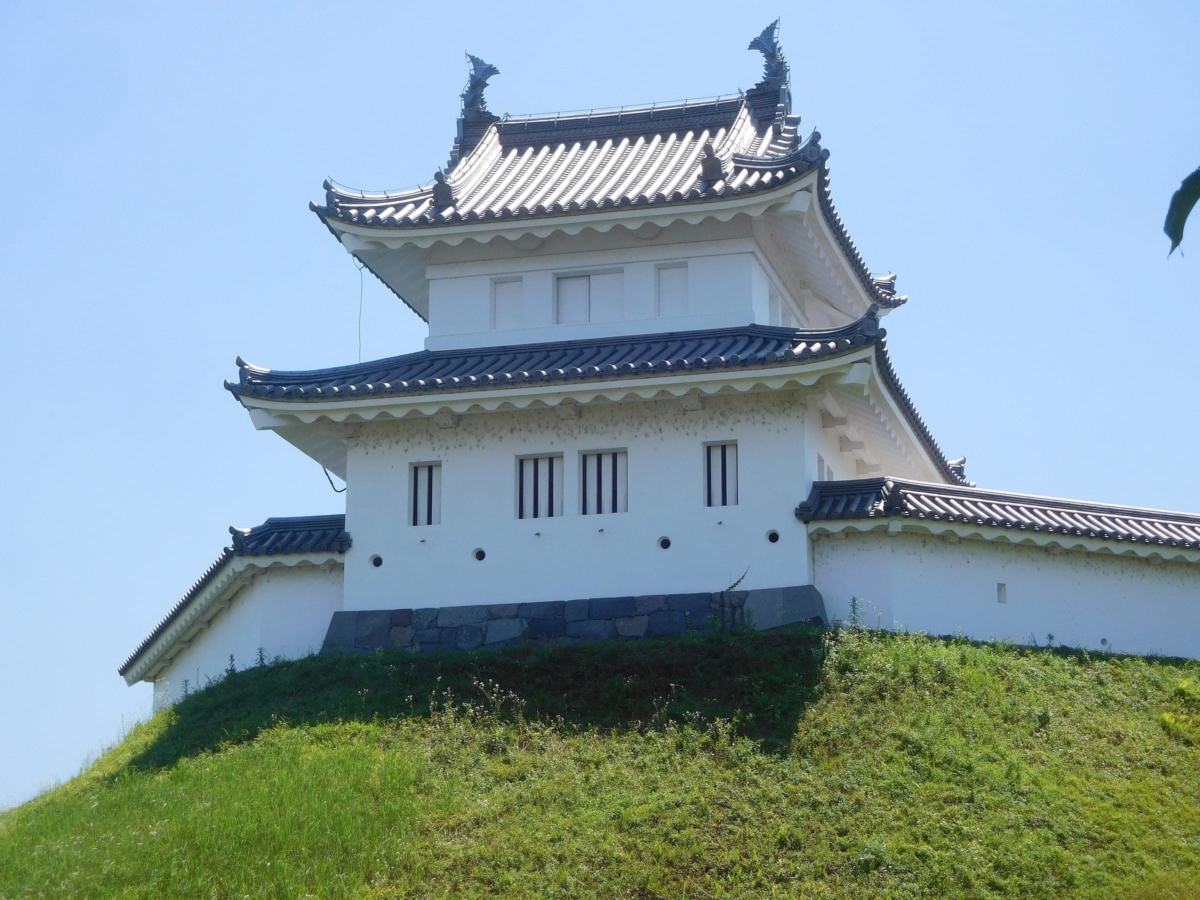 The rebuilt Seimeidai turret stands on a grassy rampart in Utsunomiya Castle Park