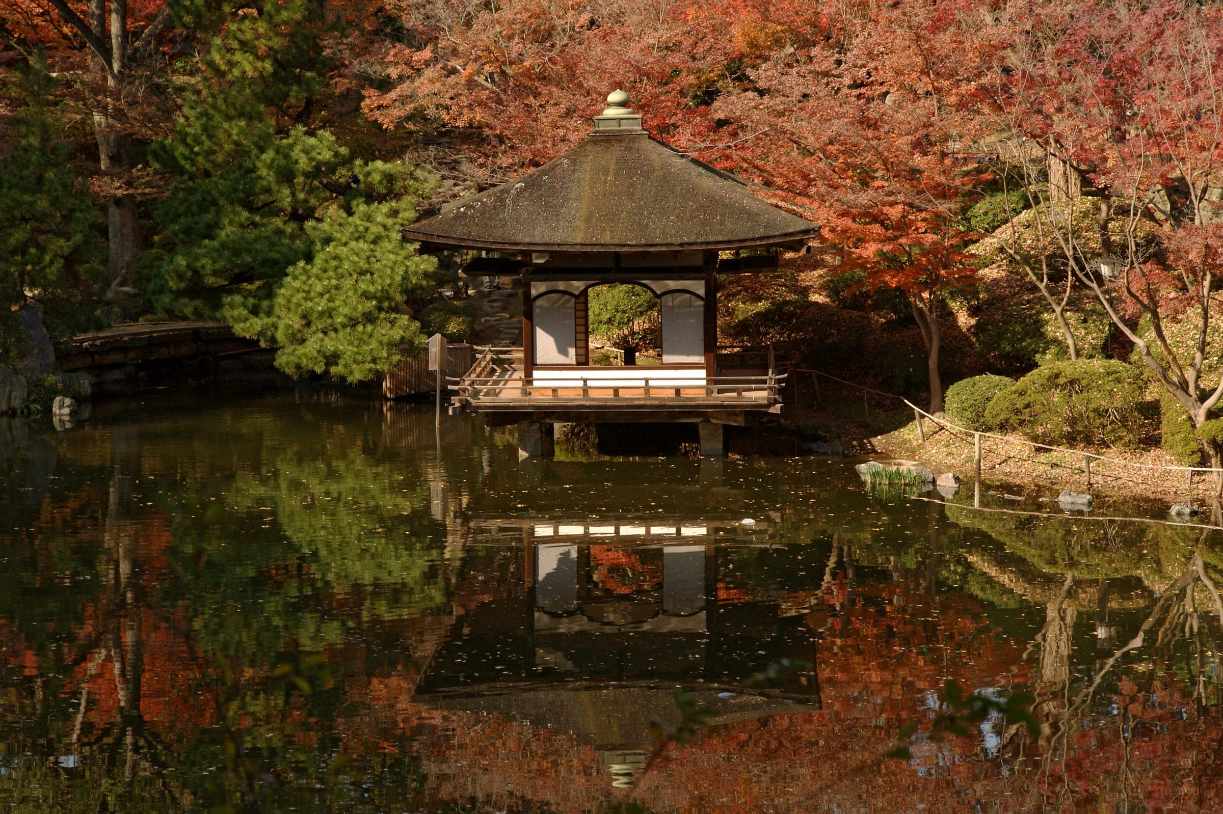 Autumn maples frame a pavilion over the pond in the Nishinomaru Garden of Wakayama Castle
