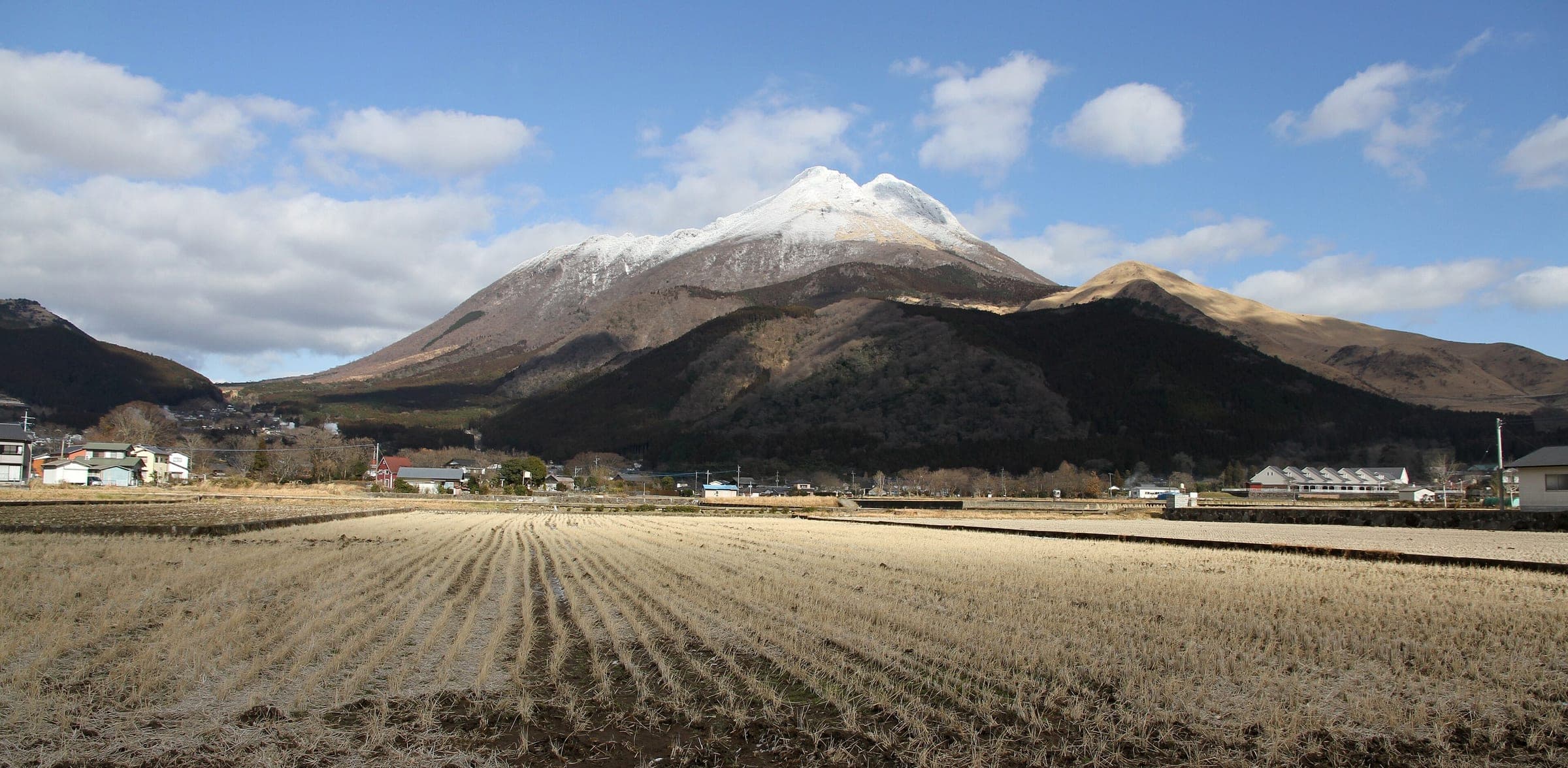 Snow caps Mount Yufu above frosted rice stubble on the edge of the Yufuin basin in January.